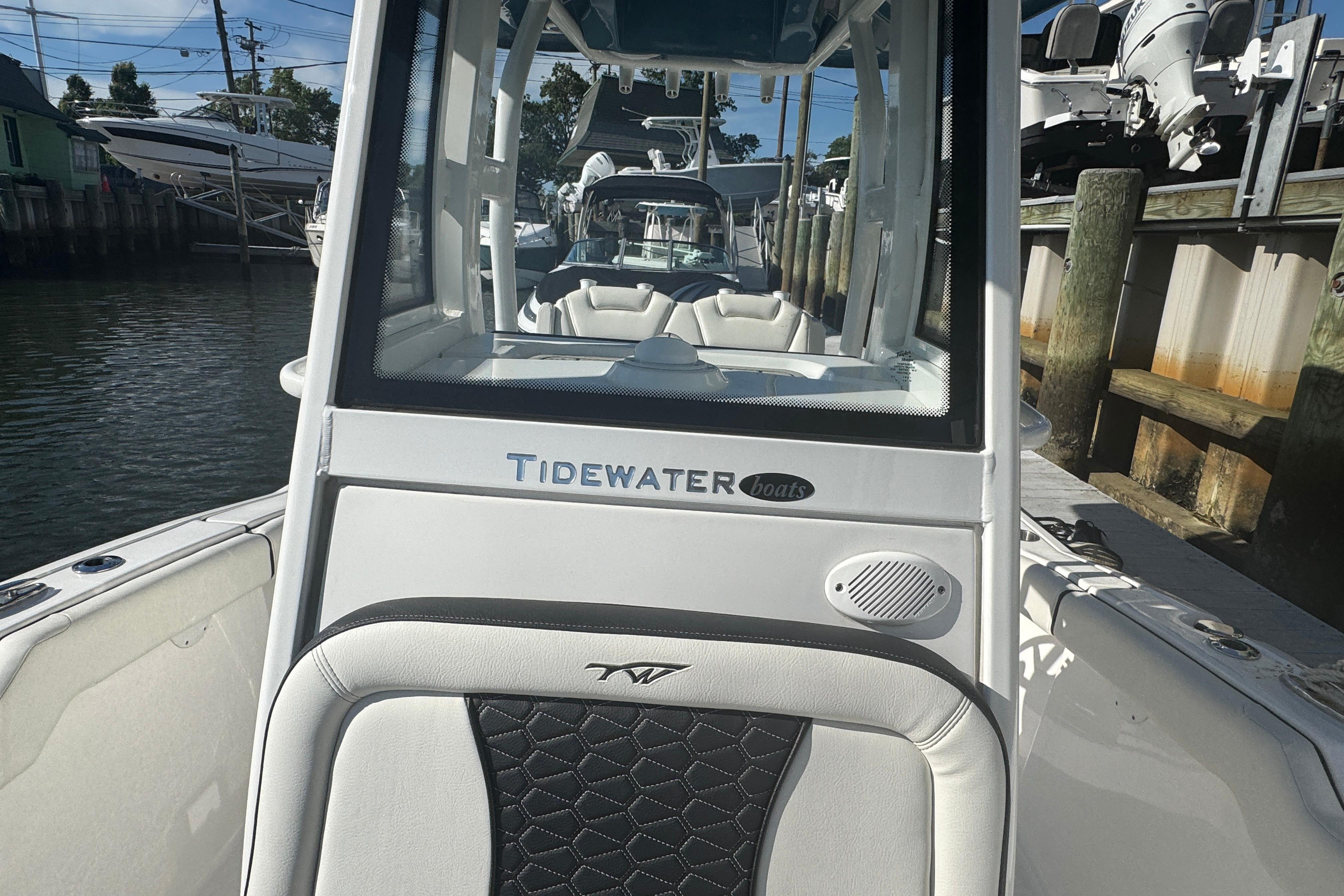 2025 Tidewater 232 LXF boat docked, showcasing sleek design and spacious seating.
