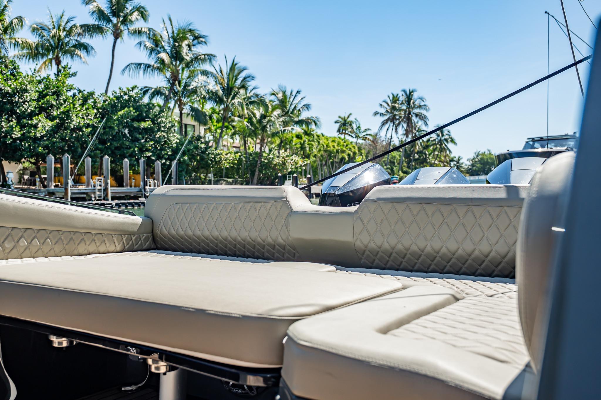 Luxurious seating on 2023 Skipper-BSK 38NC boat with palm trees in background.