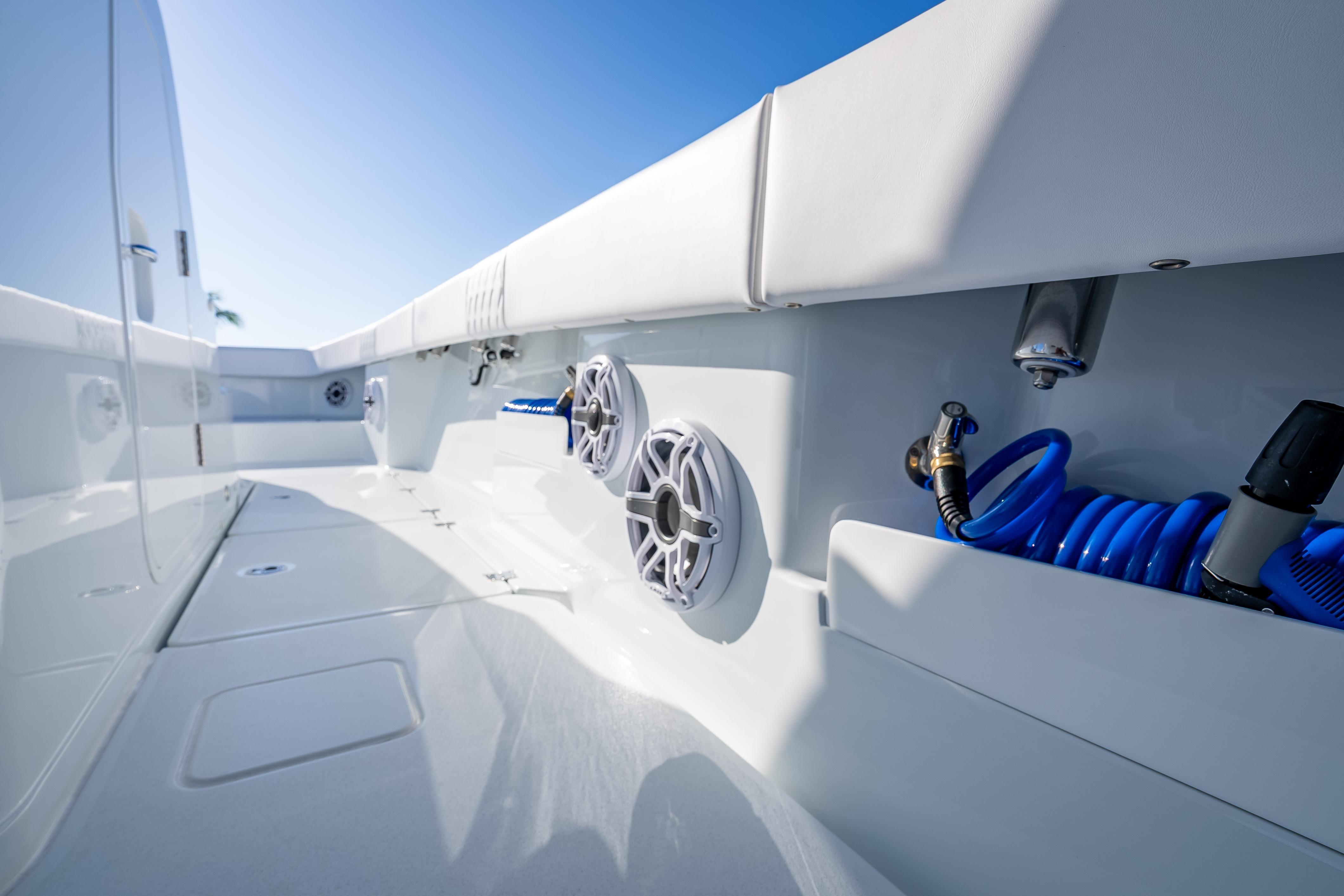 2026 Freeman 35 boat deck with speakers and coiled hose under clear blue sky.