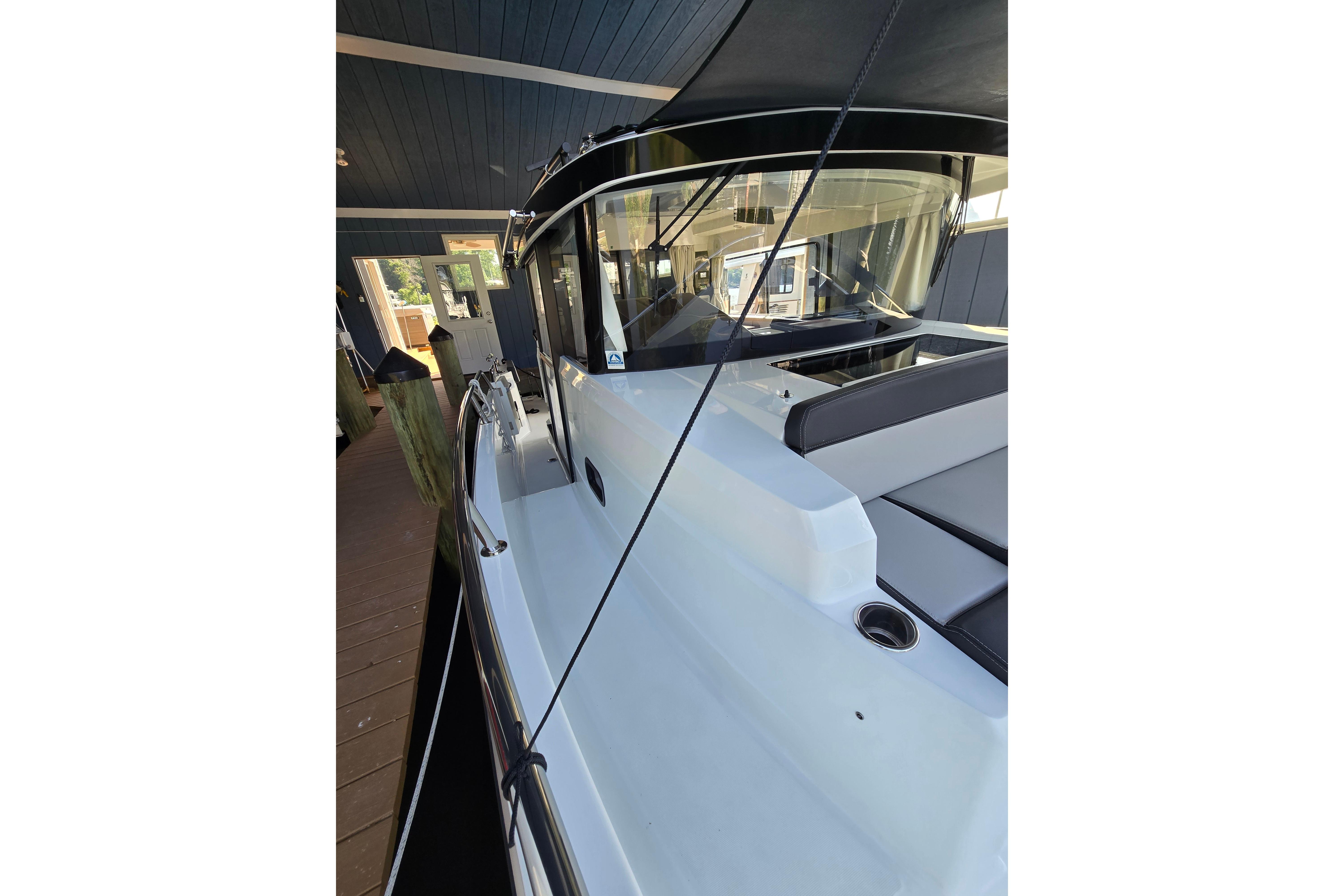 The image shows a 2023 Jeanneau NC Sport 895 docked in a covered area.