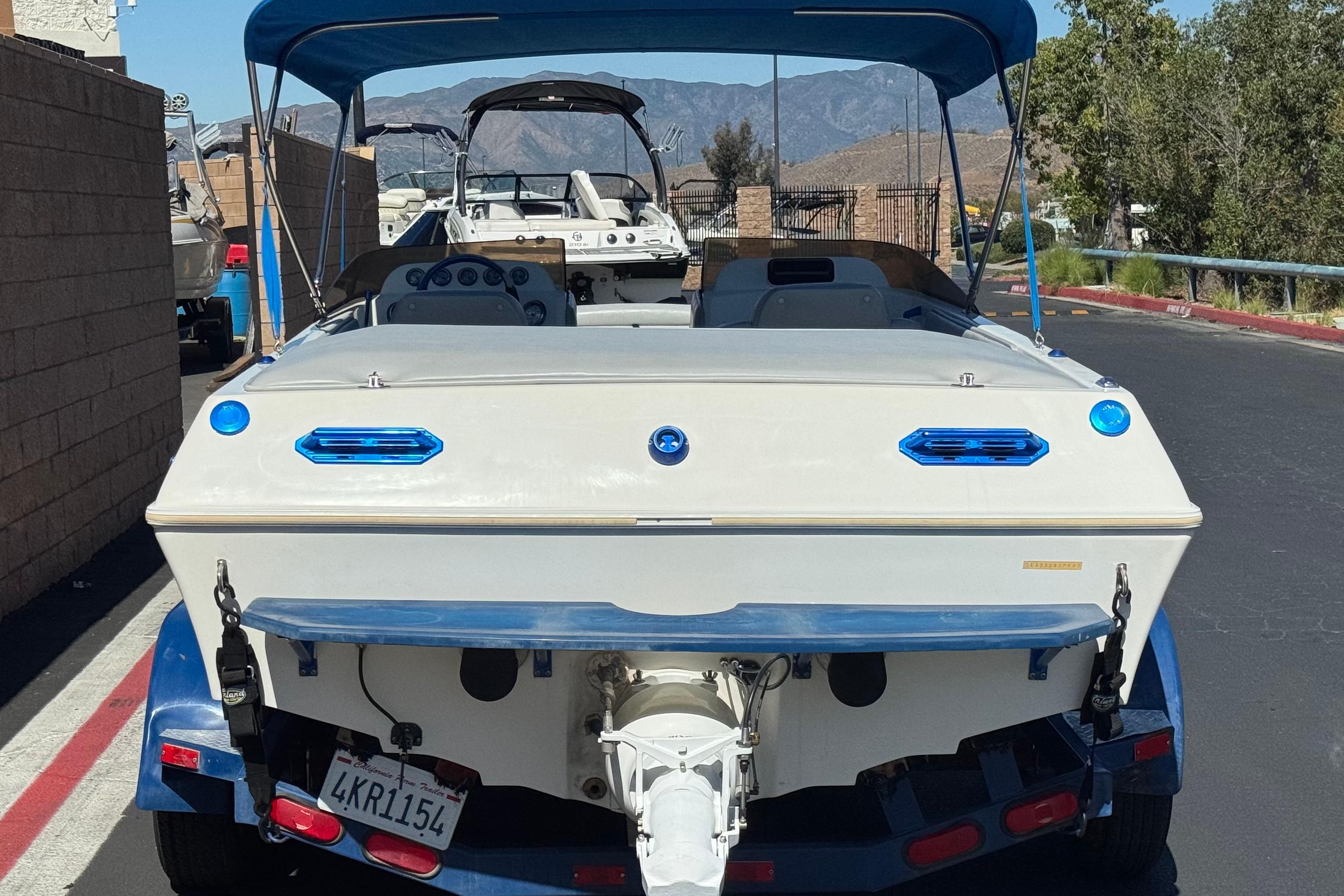 2007 Commander 2300LX boat on trailer, rear view, parked outdoors.