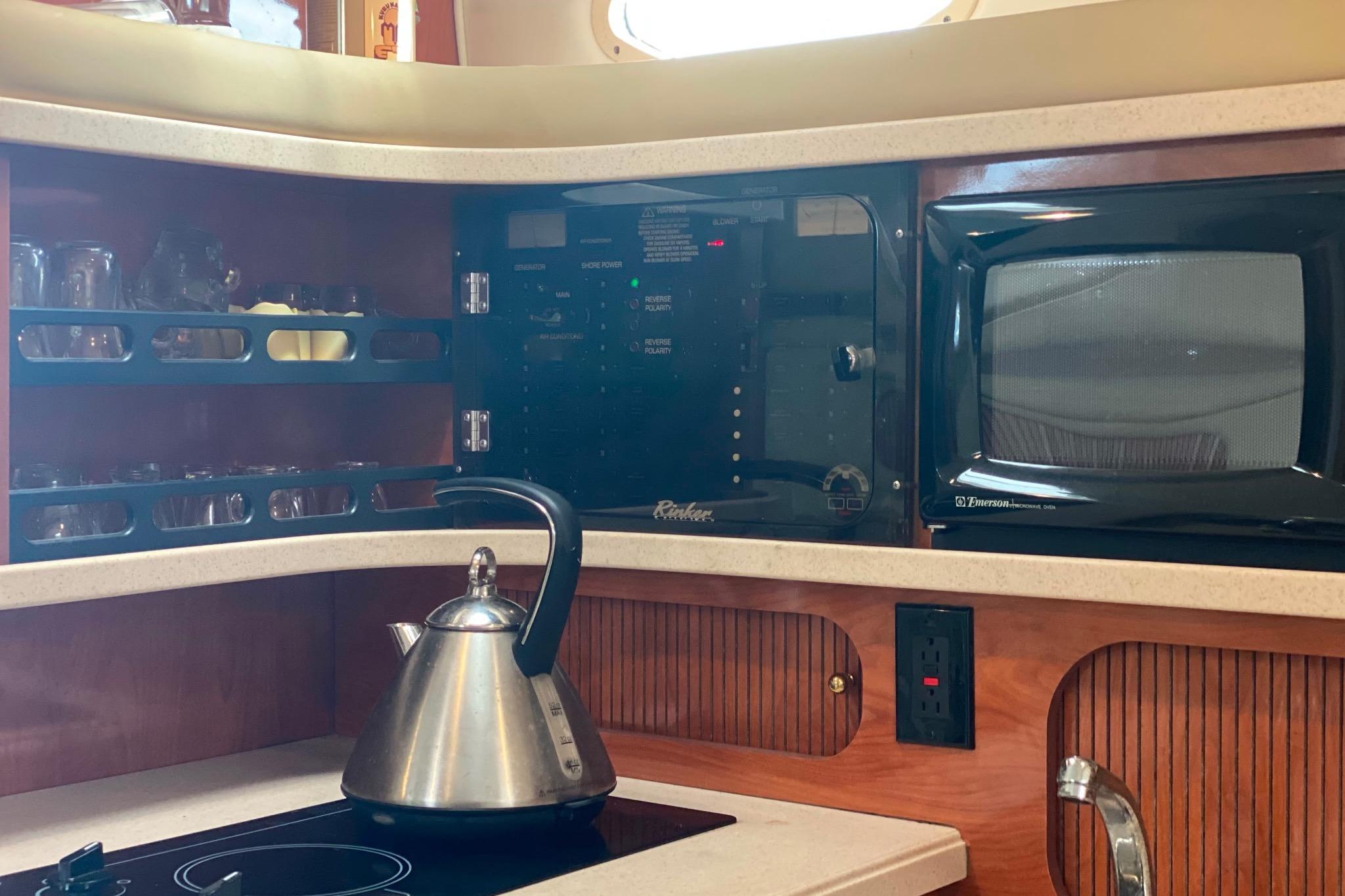 2003 Rinker Fiesta Vee 342 kitchen with kettle, microwave, and control panel.
