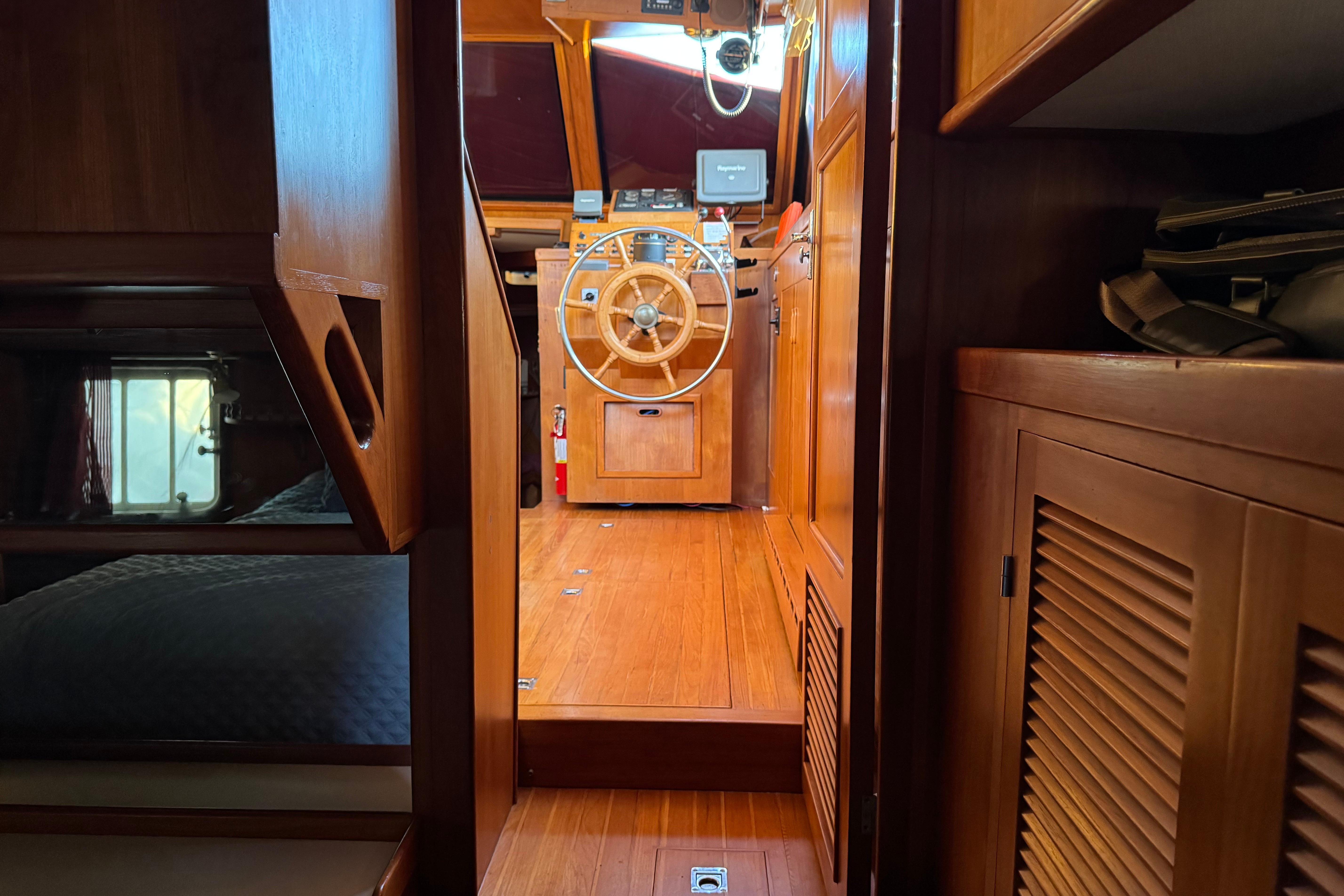 Interior of a 1987 President 37 yacht with wooden helm and cozy cabin.