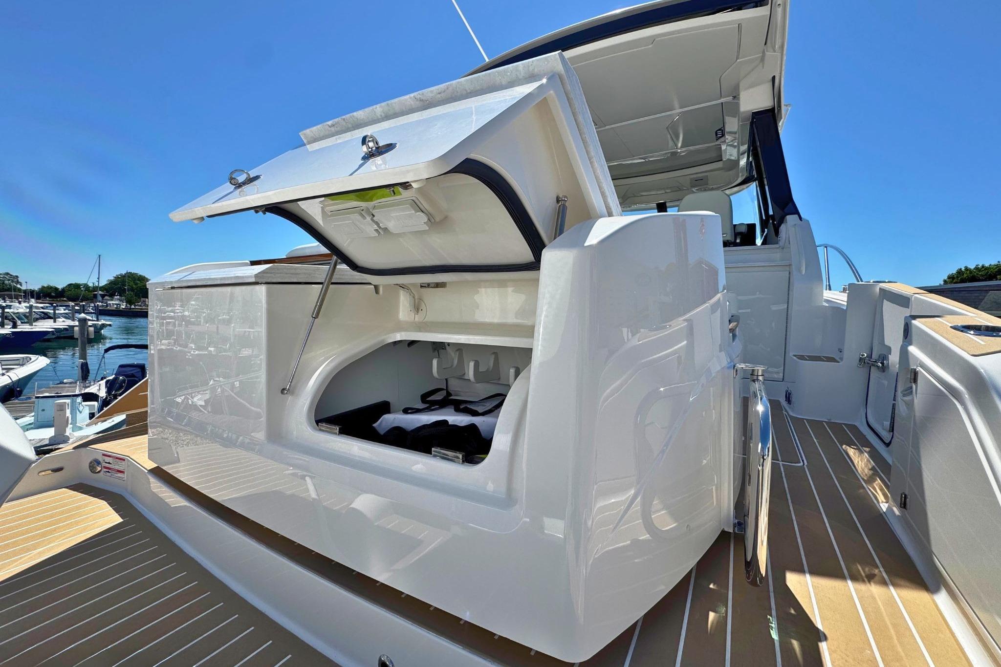 2027 Tiara Yachts 39 LE with open storage compartment on deck, docked at marina.