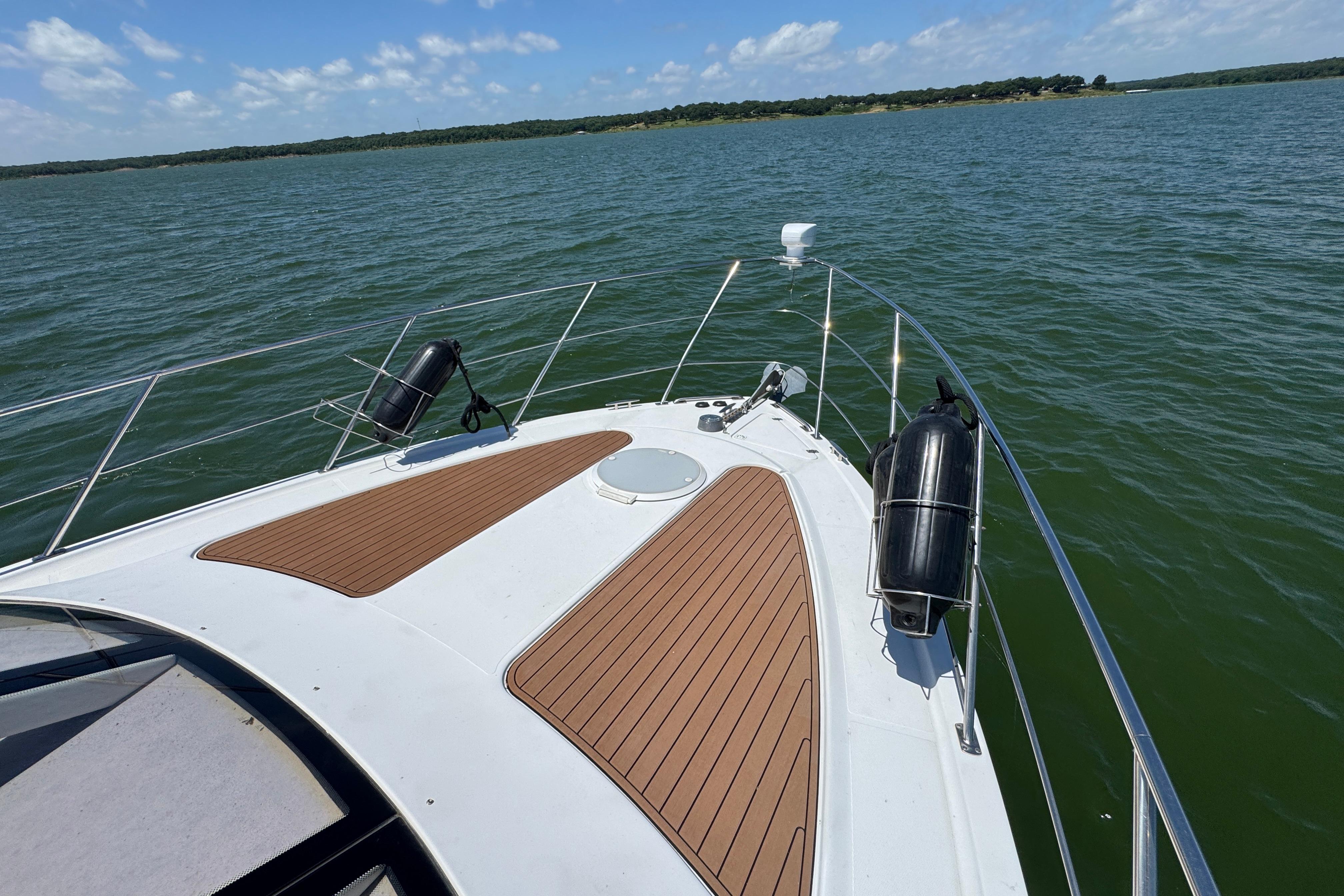 Bow view of 2002 Carver 396 Motor Yacht on a serene lake.