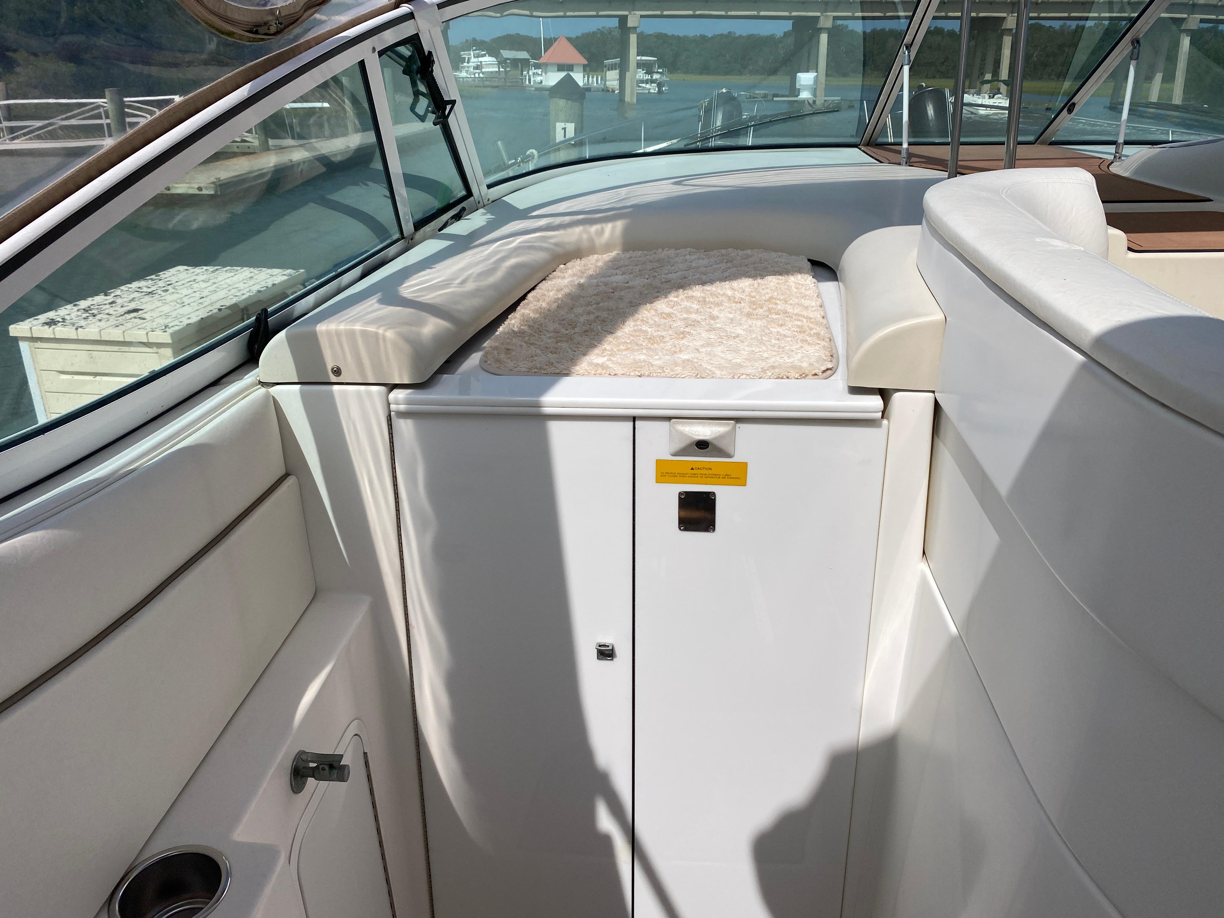 Interior of 2000 Cruisers 3672 yacht with white seating and storage compartment.