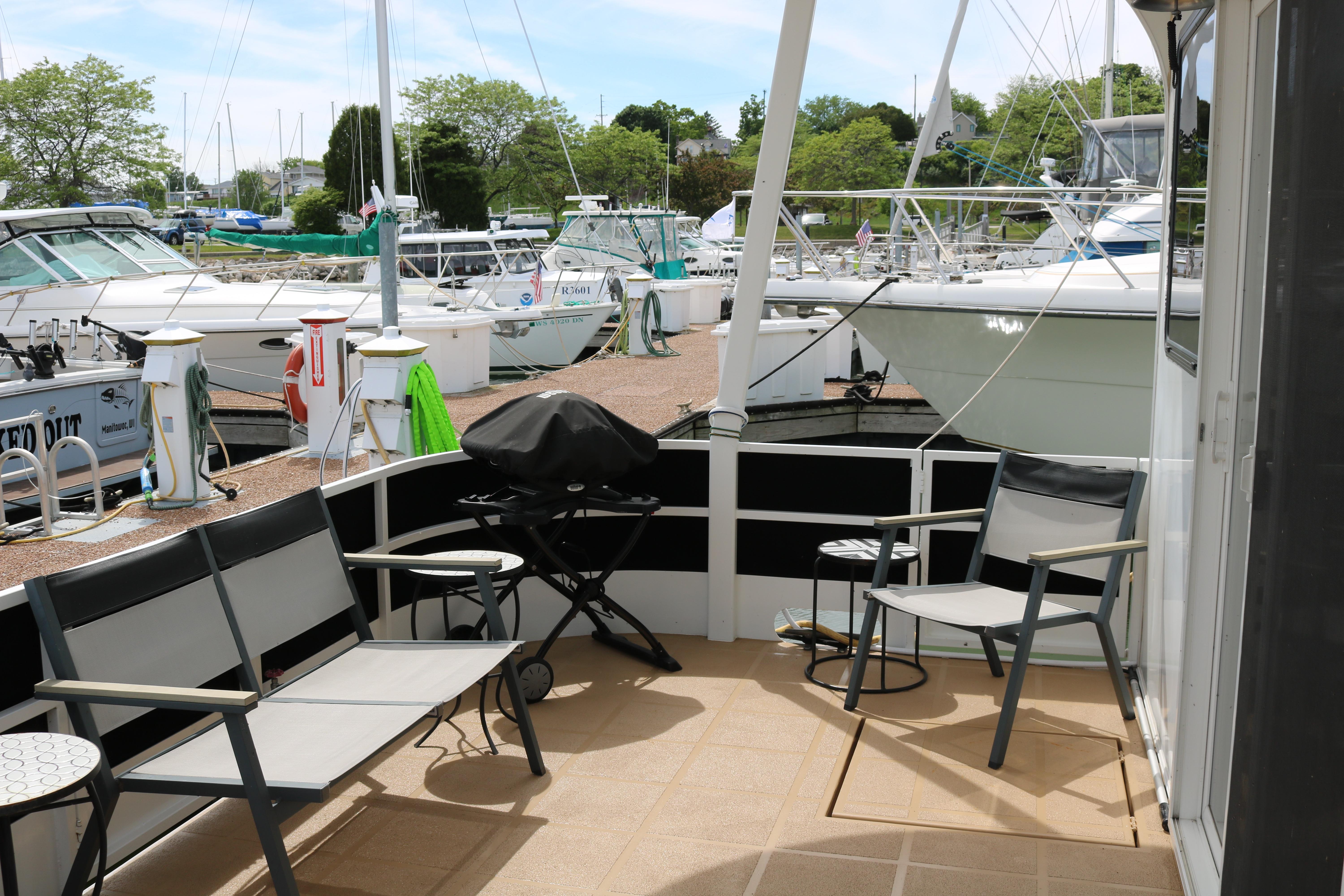 Outdoor seating area on a 2010 Skipperliner 480 Flybridge yacht at a marina.