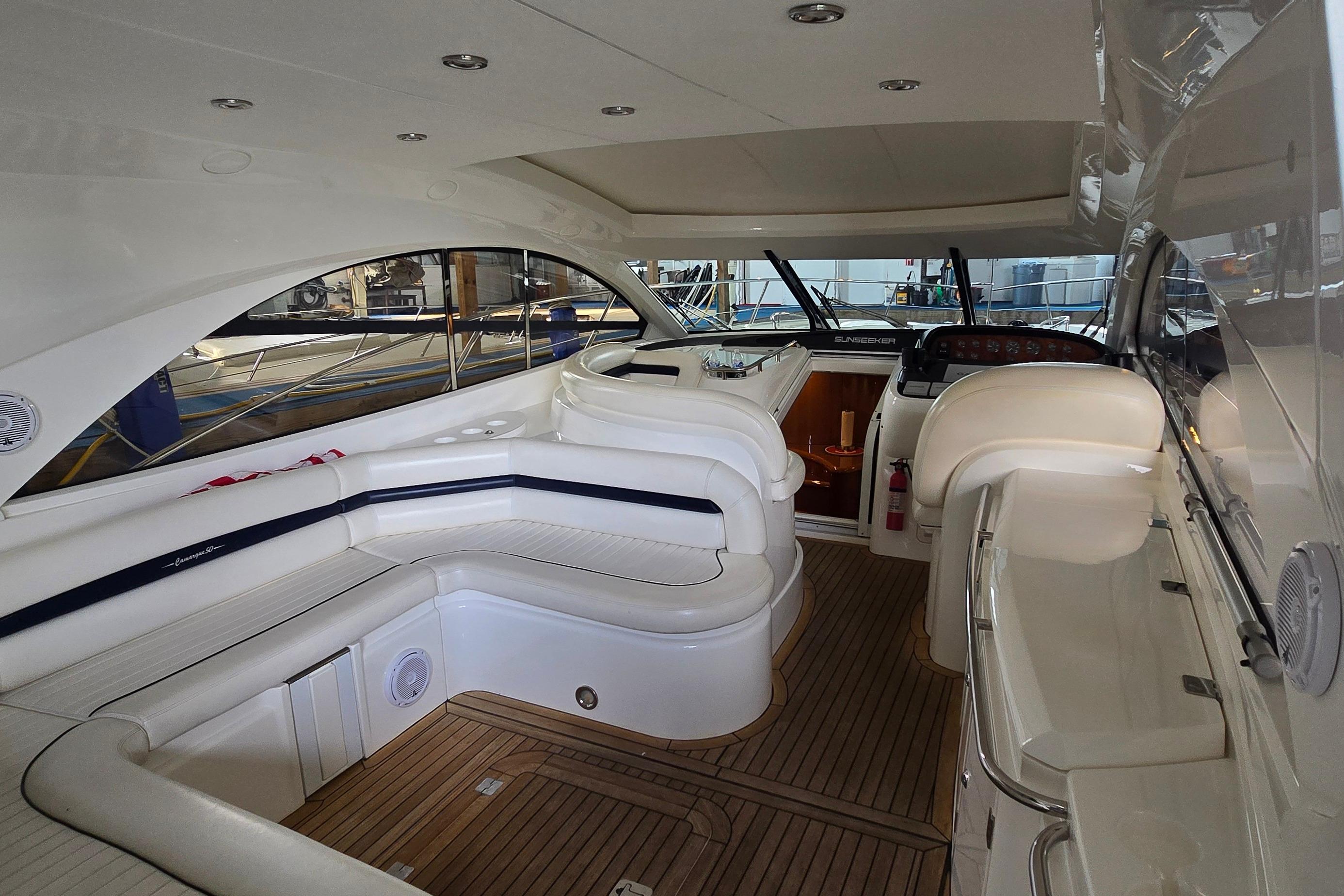 Luxurious interior of a 2004 Sunseeker Camargue 50 yacht with elegant seating and wood flooring.