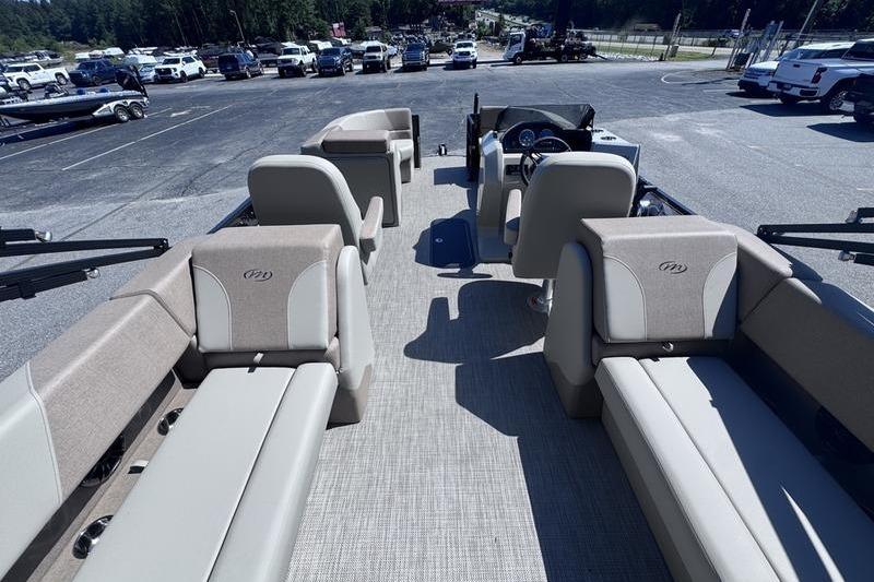 2027 Manitou Aurora 23 RF SHP pontoon boat interior with beige seating and steering console.