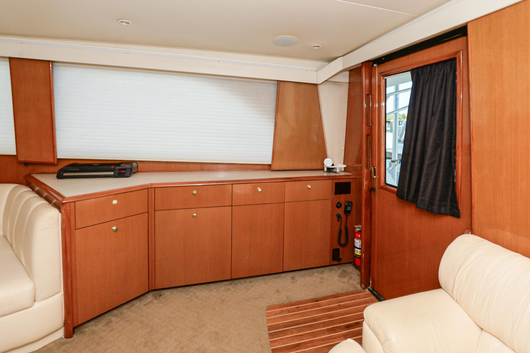 Interior of 1999 Viking 55 Convertible yacht with wooden cabinetry and beige seating.