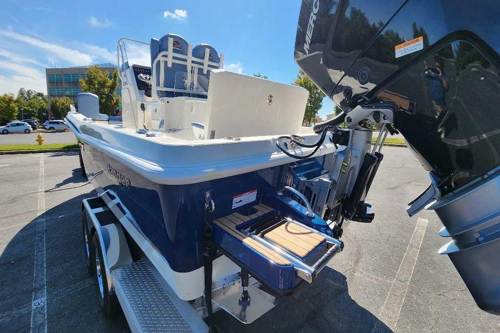 2025 Ranger 2510 Bay boat with outboard motor, parked on a trailer in a sunny lot.