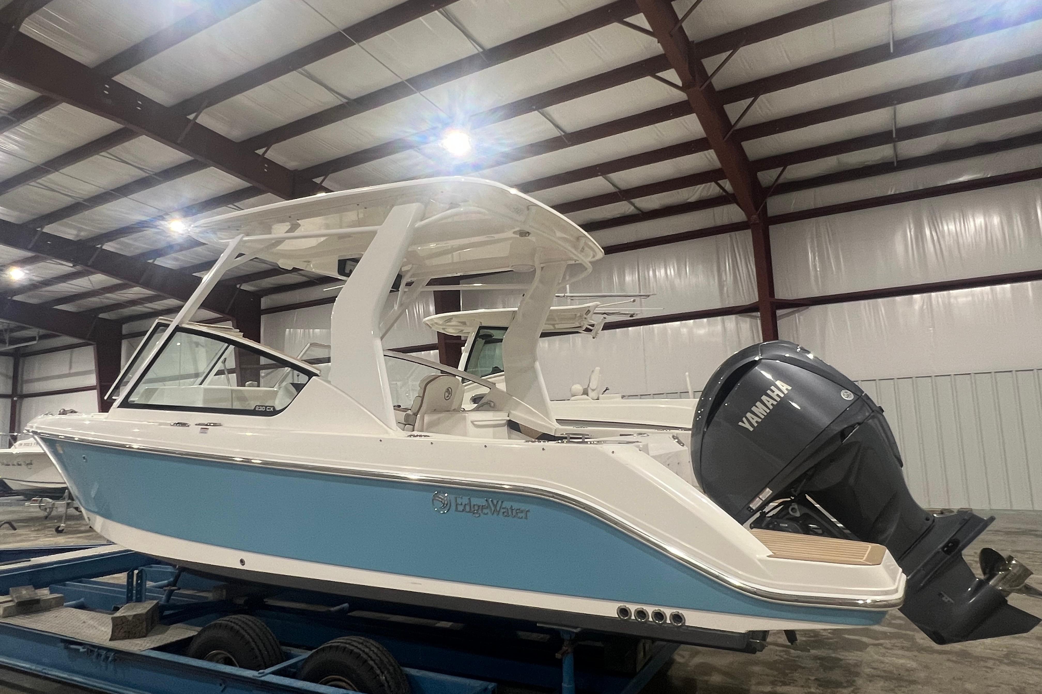 2023 Edgewater 230CX Crossover boat with Yamaha engine in a warehouse setting.