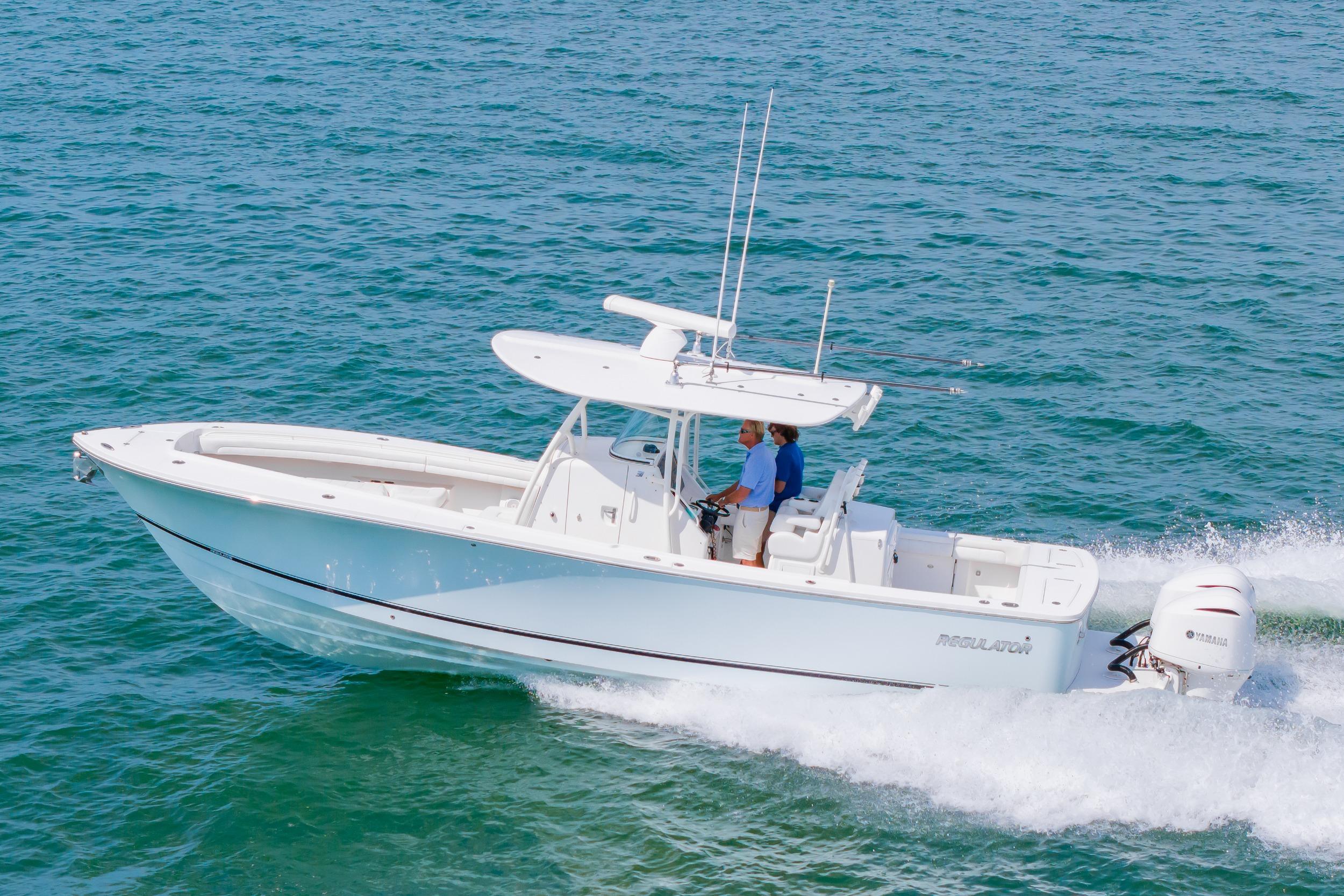 2019 Regulator 31 boat cruising on open water with two people onboard.