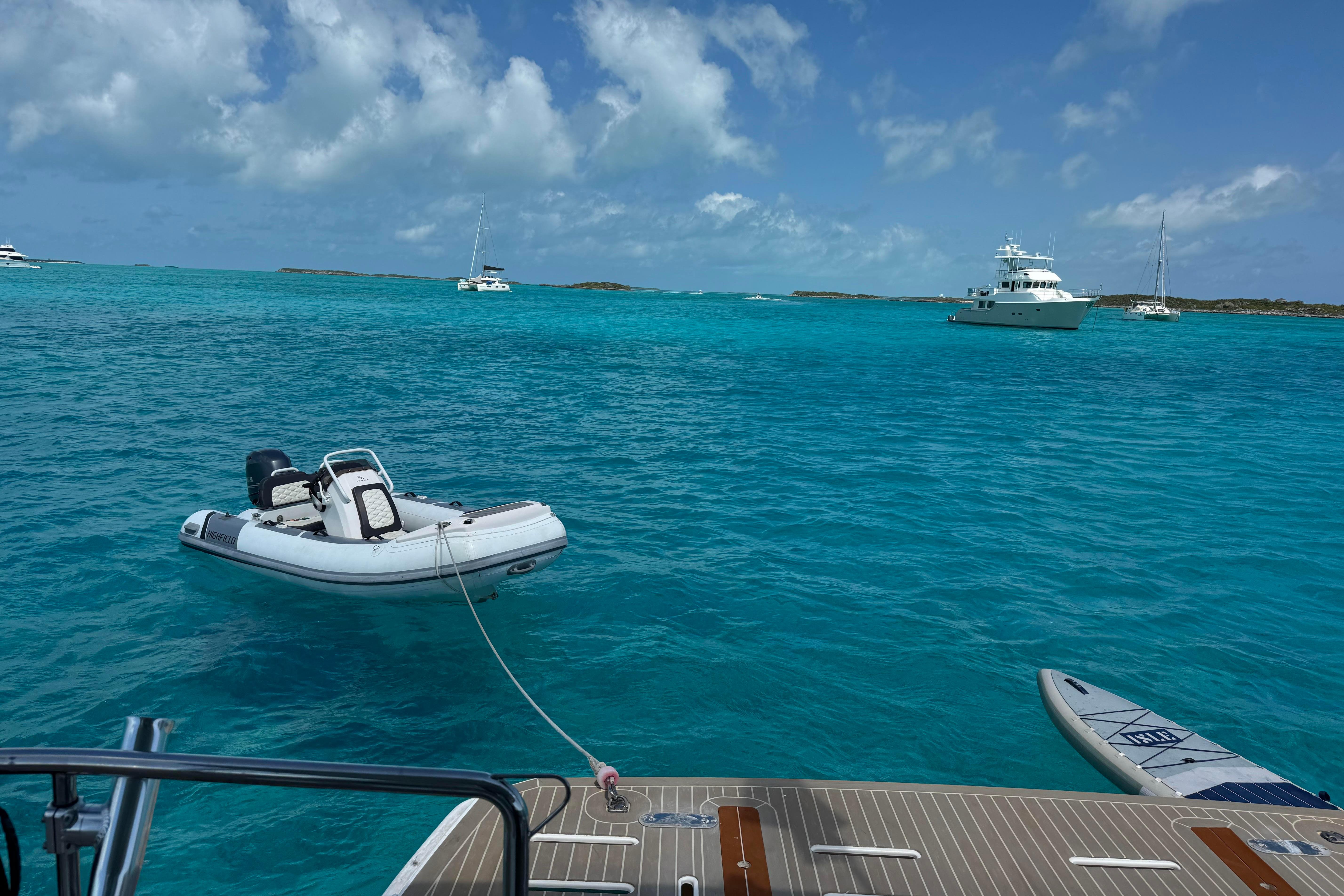 A 2021 Leopard 53 Powercat with dinghy and paddleboard in turquoise waters.