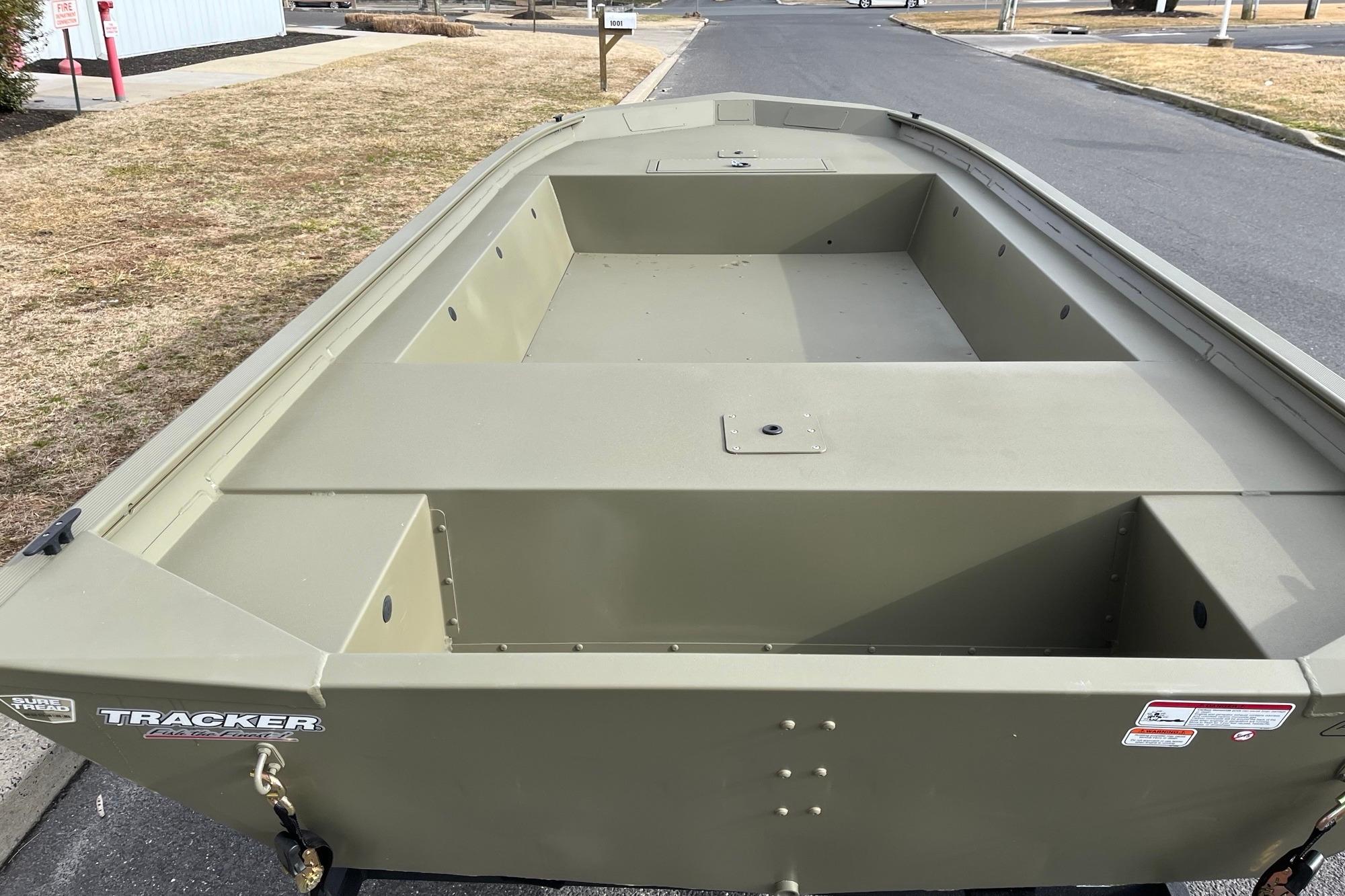 2026 Tracker Grizzly 1754 Utility boat, olive green, parked on a street.