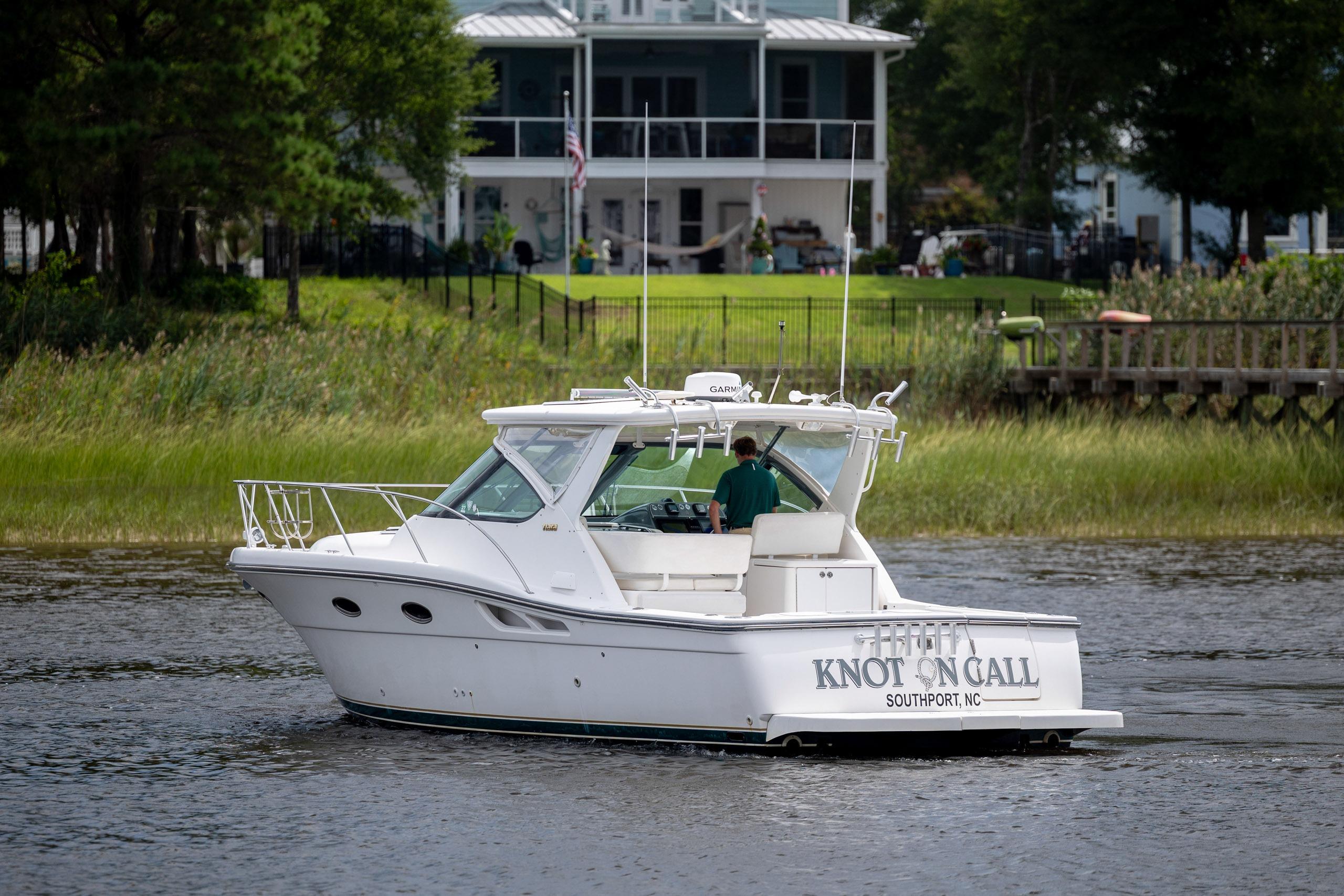 2004 Tiara Yachts 3200 Open cruising near a waterfront home.