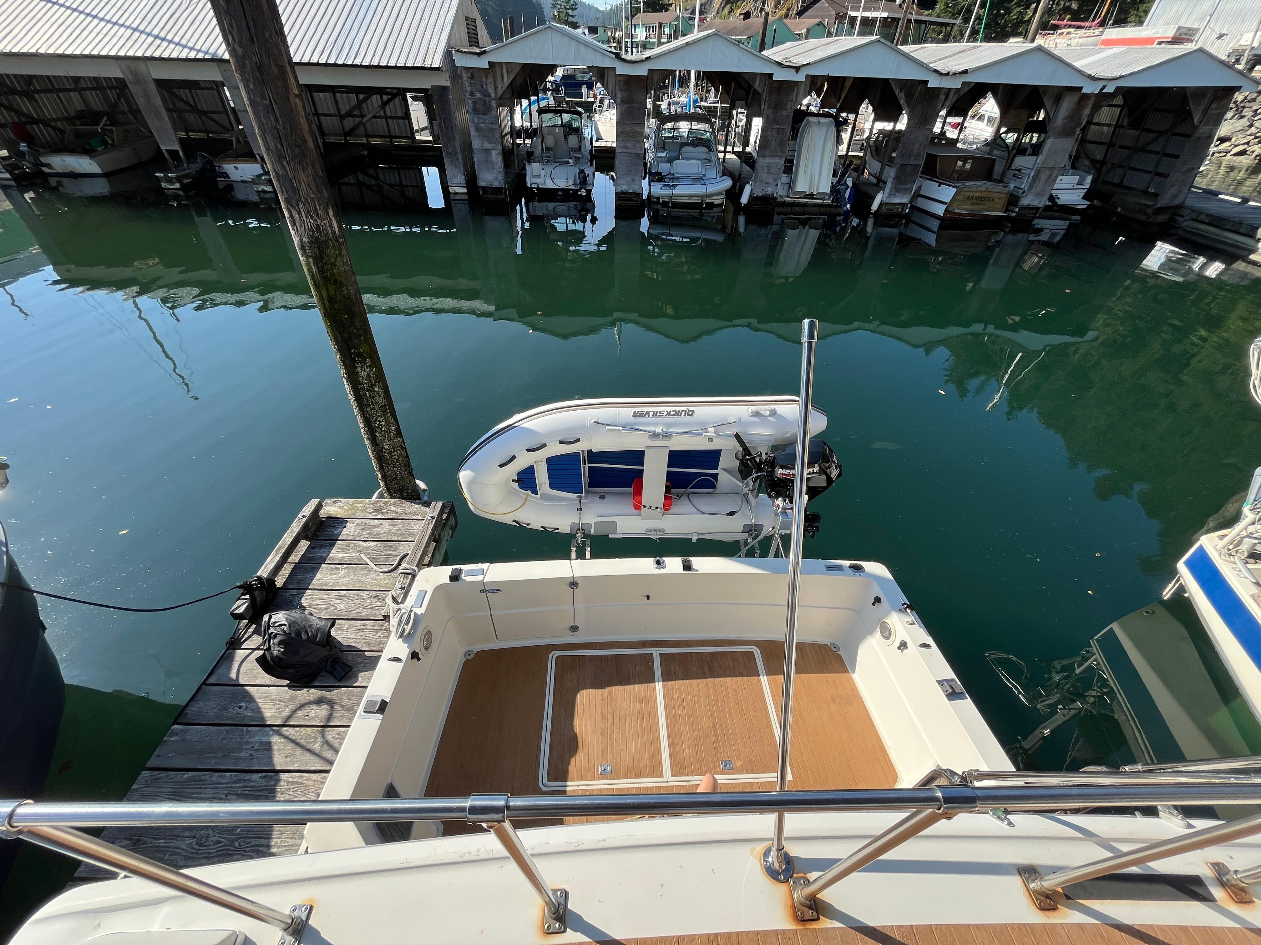 1976 Fiberform Executive 3300 boat docked at marina with small dinghy nearby.