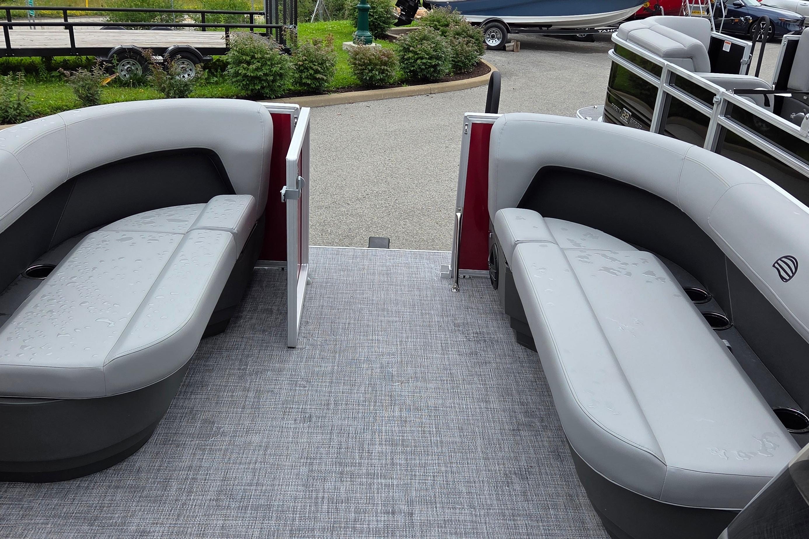 2026 Sun Tracker Party Barge 16 DLX interior with gray seating and open gate.