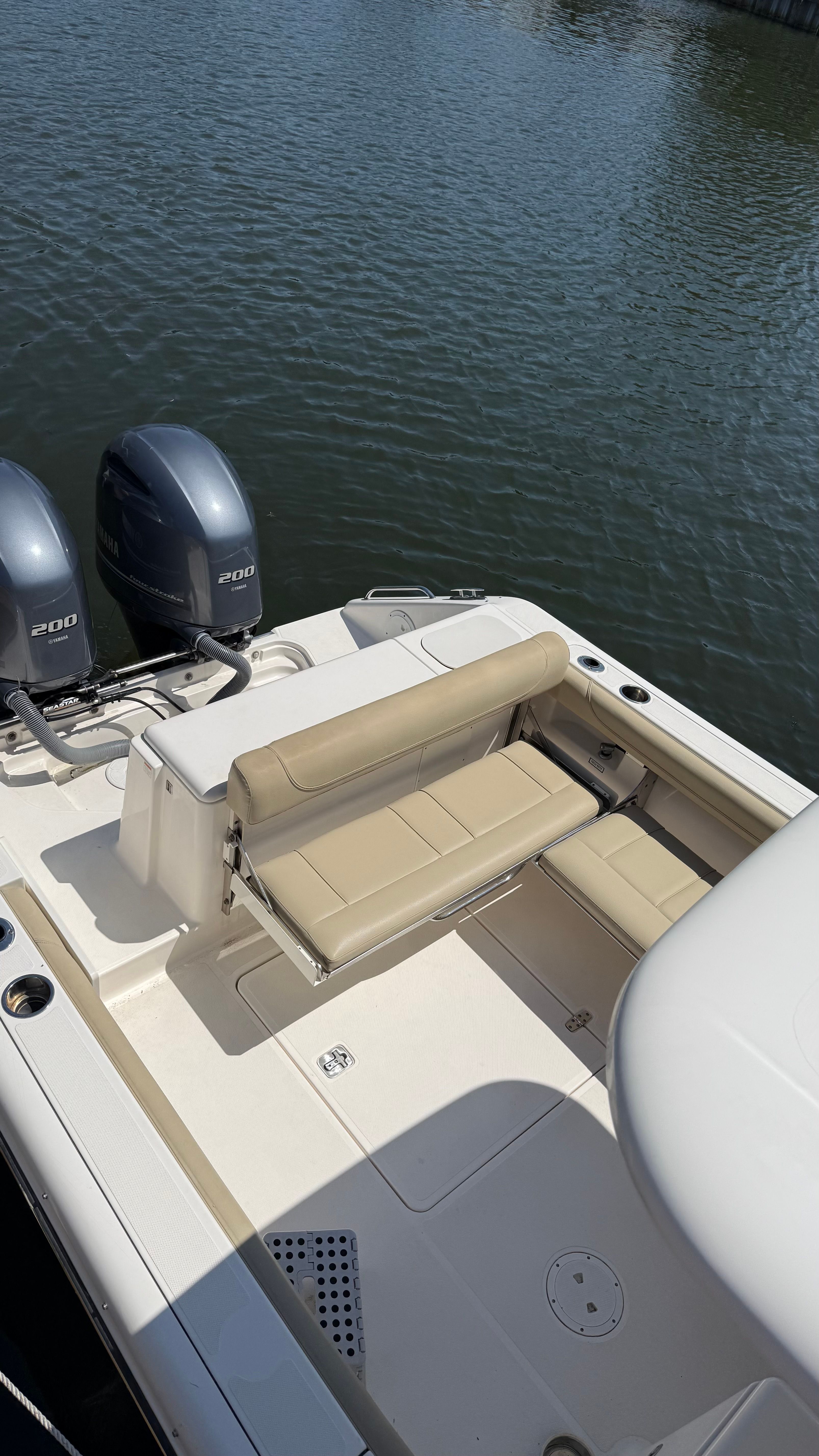 A 2016 Pursuit DC 265 Dual Console boat with twin outboard engines on calm water.