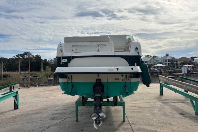 2001 Crownline 242 CR boat on a dock, rear view, under a cloudy sky.