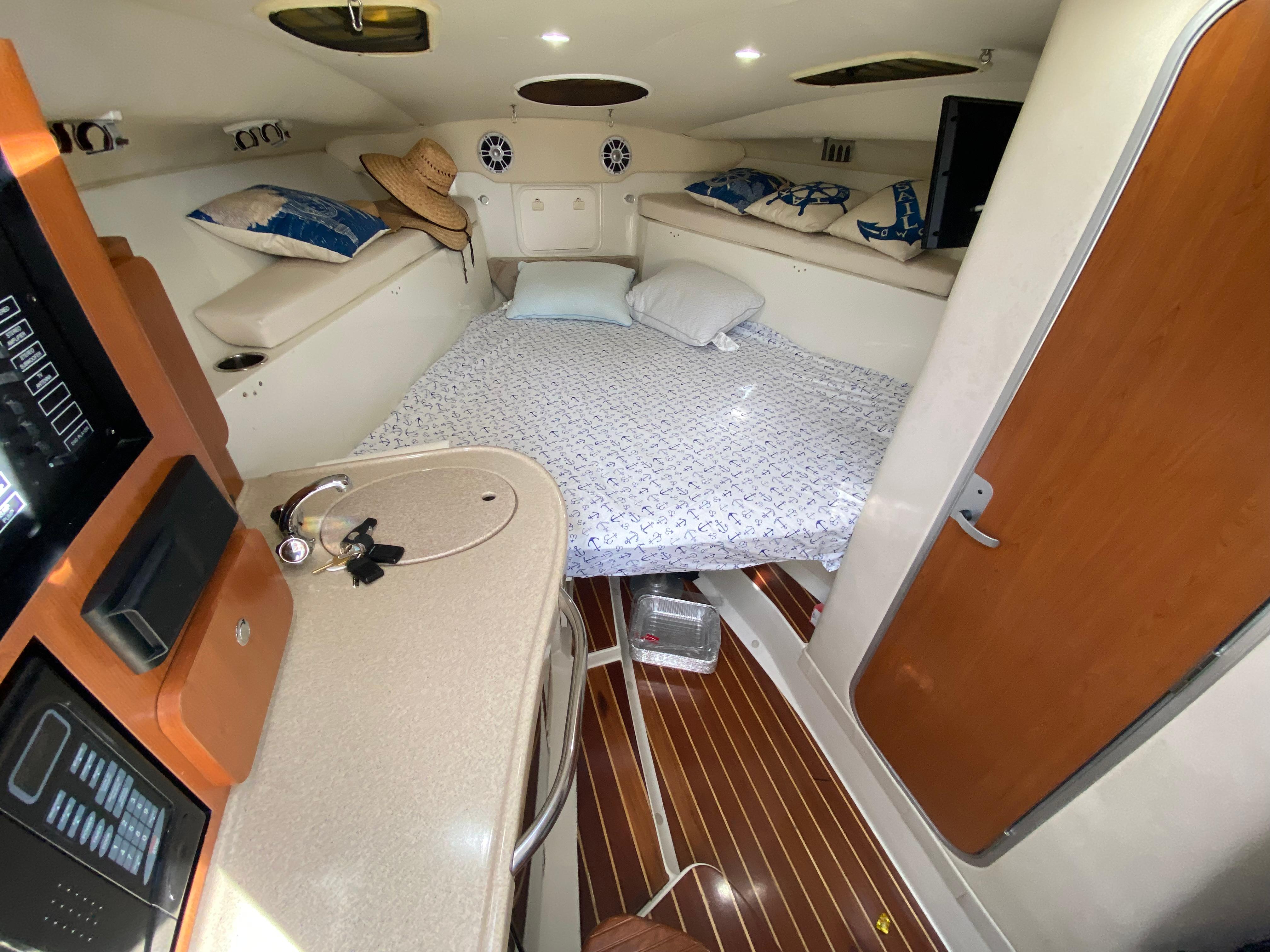 2006 Hydra-Sports Vector 3300 VX cabin interior with bed, sink, and wooden flooring.