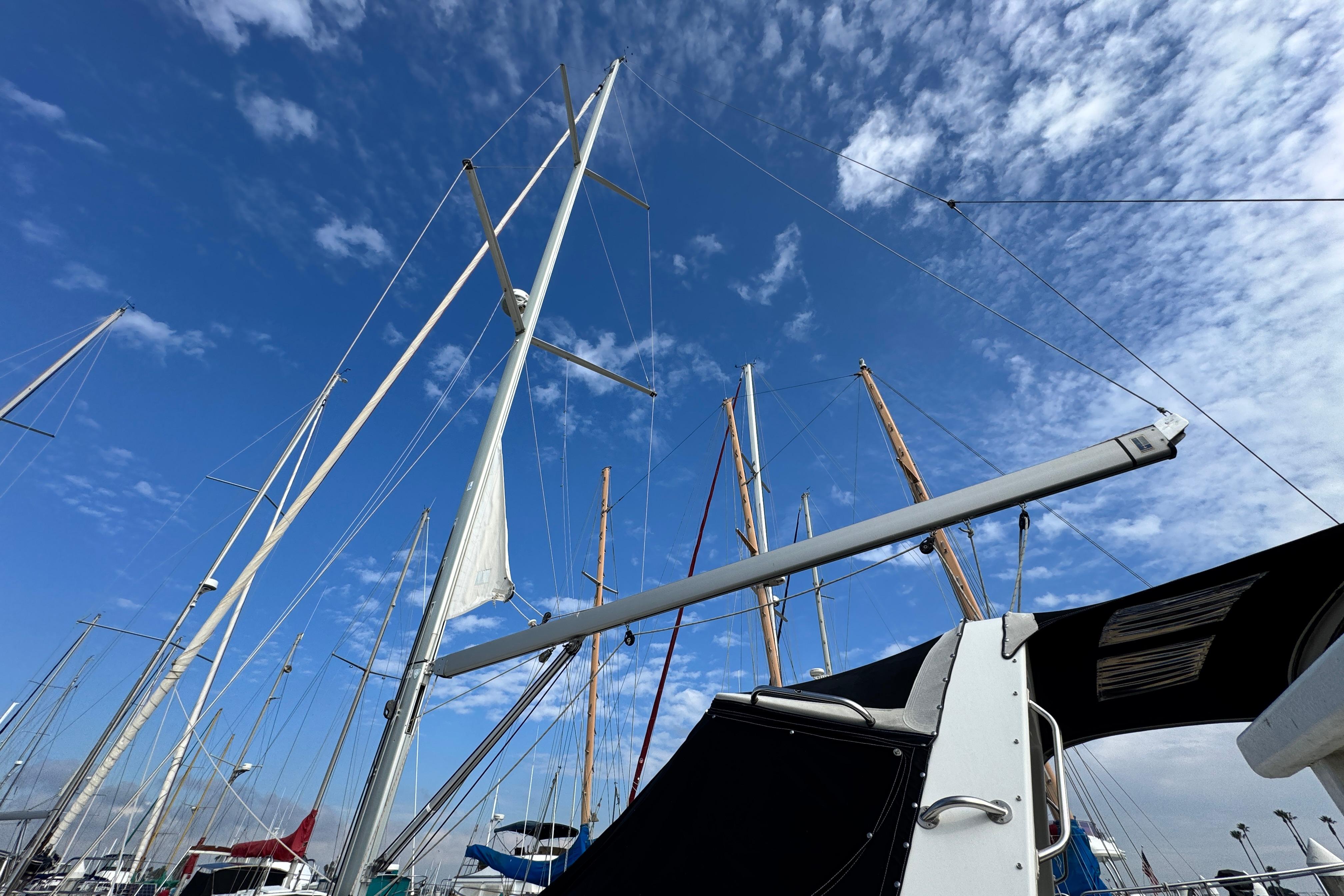 Sailboat masts against a blue sky, featuring a 2016 Beneteau Oceanis 48.