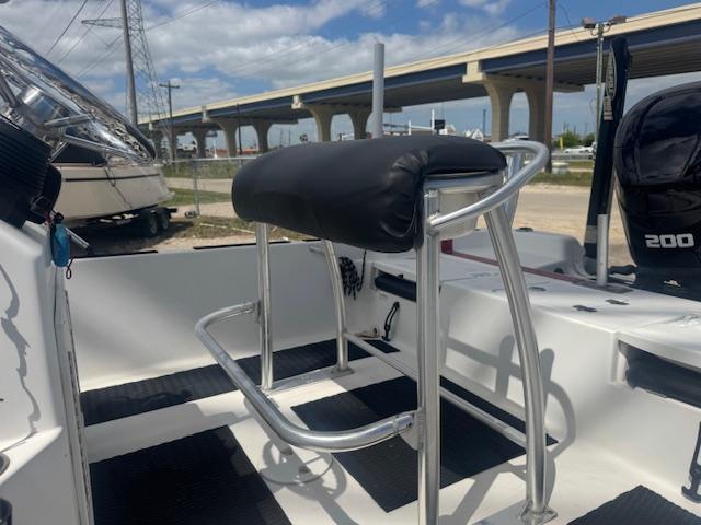 2010 NauticStar 2110 Nautic Bay boat interior with seating and console, under a clear sky.
