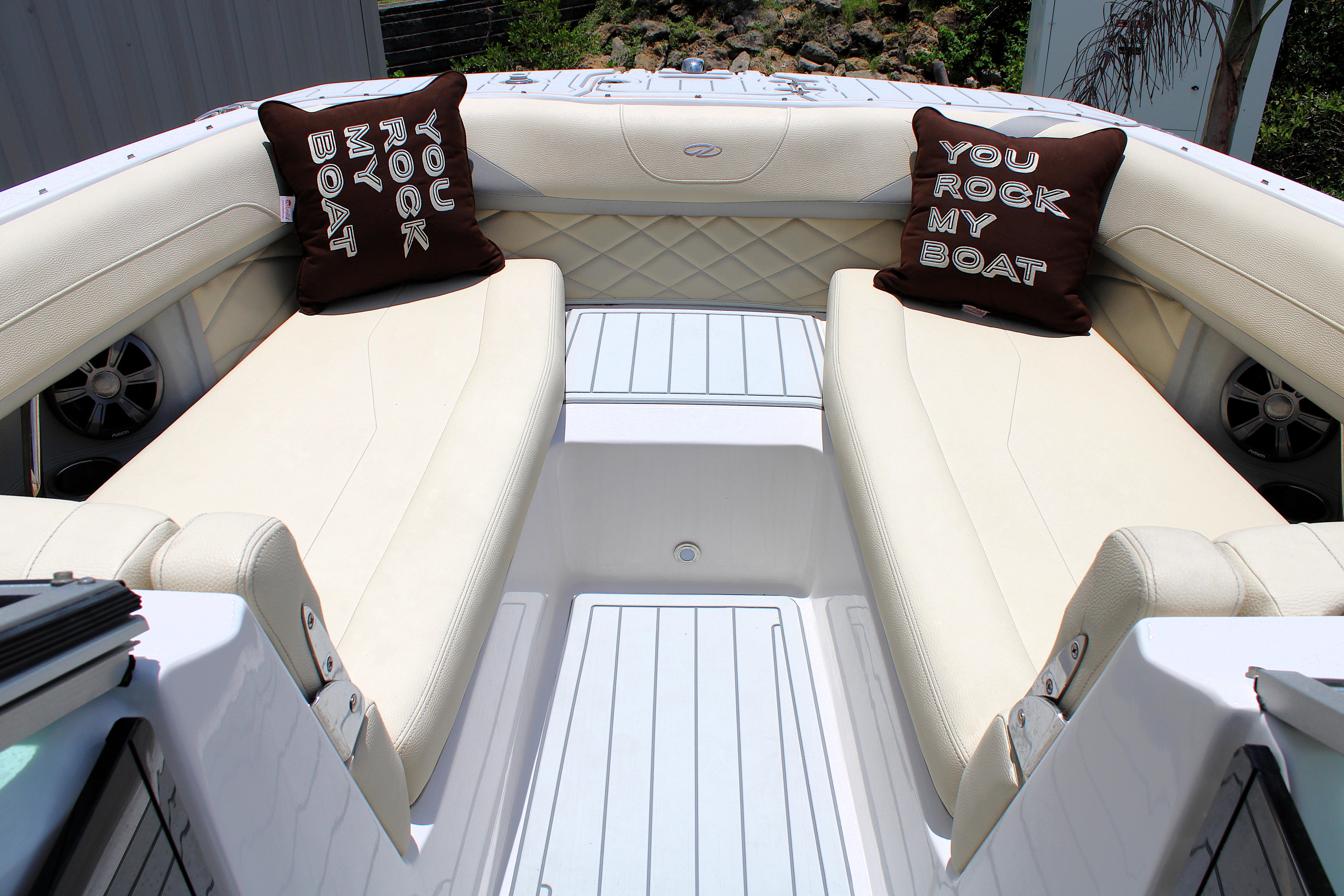 Luxurious seating on 2021 Regal 26 OBX boat with decorative pillows.
