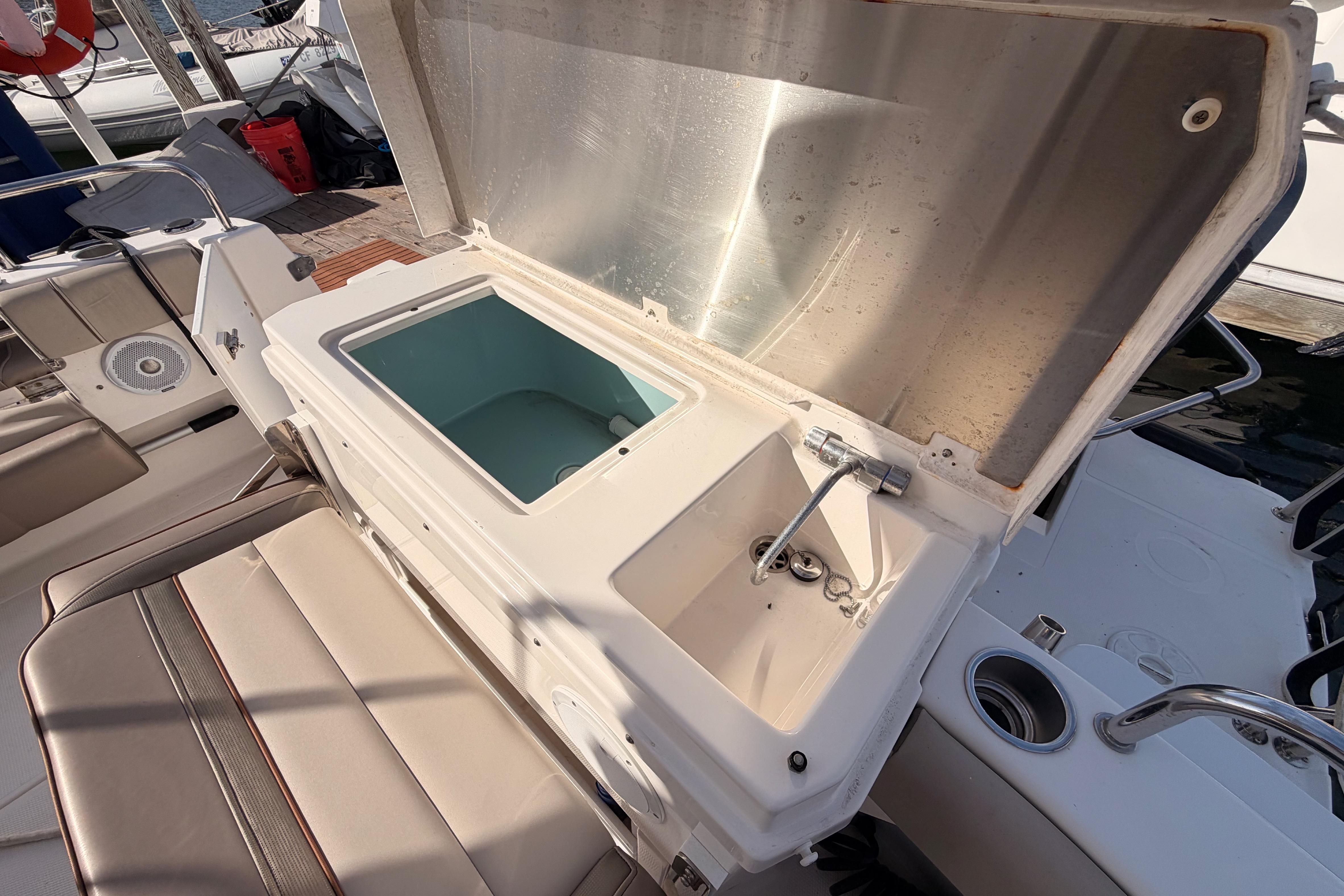 2021 Cutwater C-32 CB boat with open storage compartment and seating area.