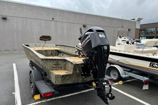 2026 Tracker Grizzly 1756 T Marsh boat with Mercury 60 engine in parking lot.