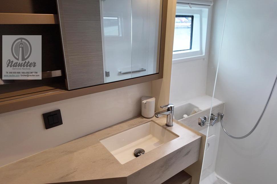 Modern bathroom interior of 2023 Lagoon 46 yacht with sleek sink and shower.