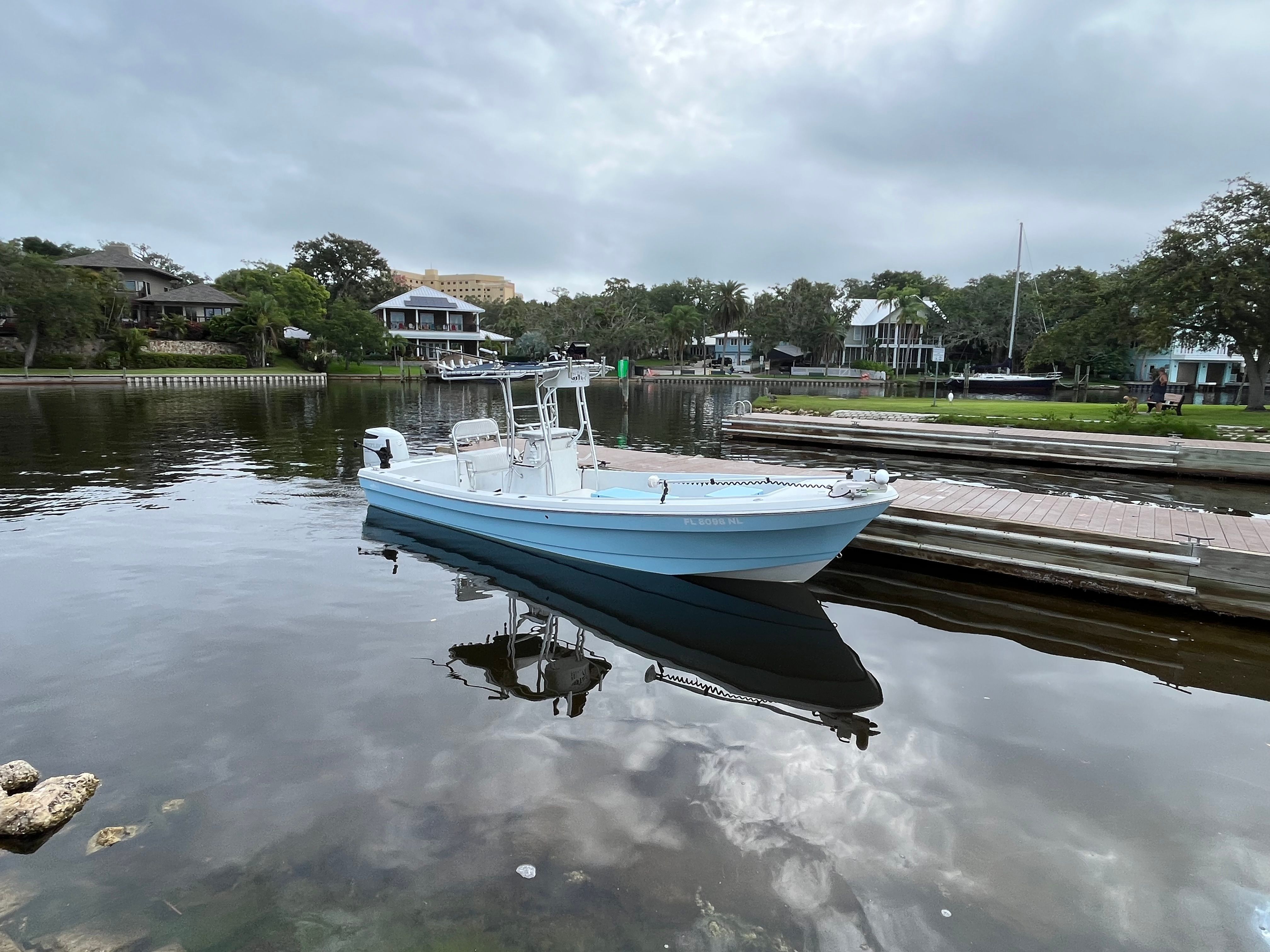 A 2007 Andros 26 Tarpon boat sits calmly on the water in a peaceful harbor.