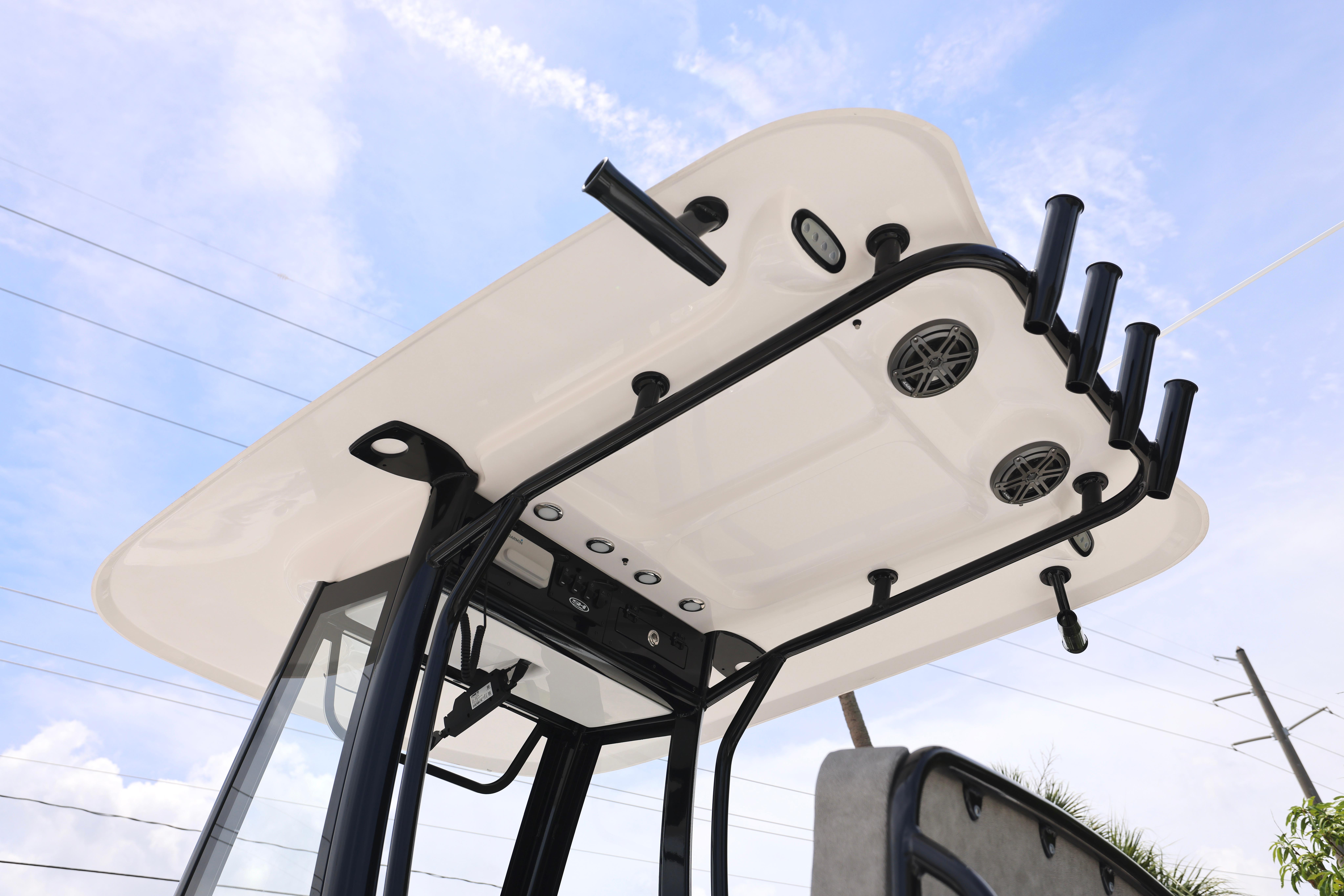 2026 Sea Hunt Ultra 245 SE boat top view with rod holders and speakers against blue sky.