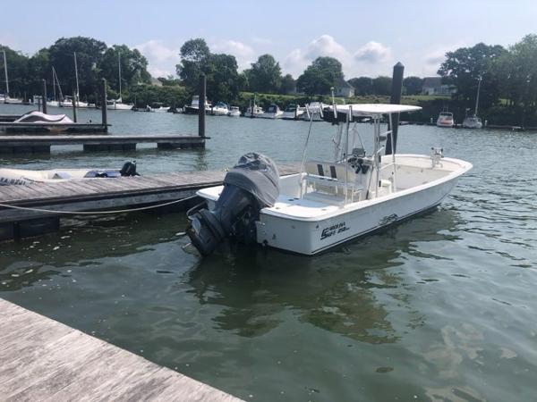 2011 Carolina Skiff 258 DLV boat docked in a serene marina setting.