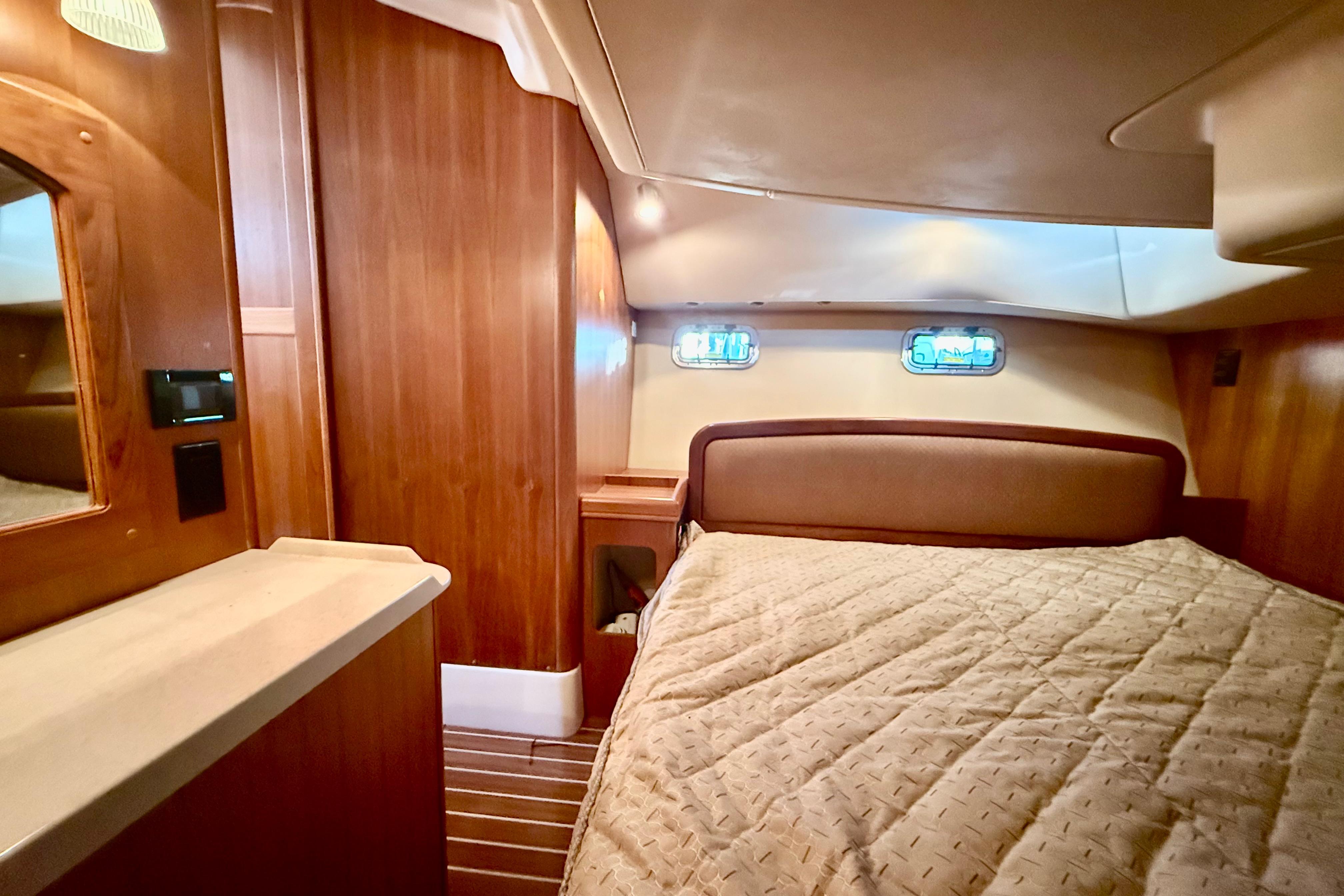 Luxurious interior of 2007 Hunter 41 Deck Salon yacht with cozy bed and wooden finish.