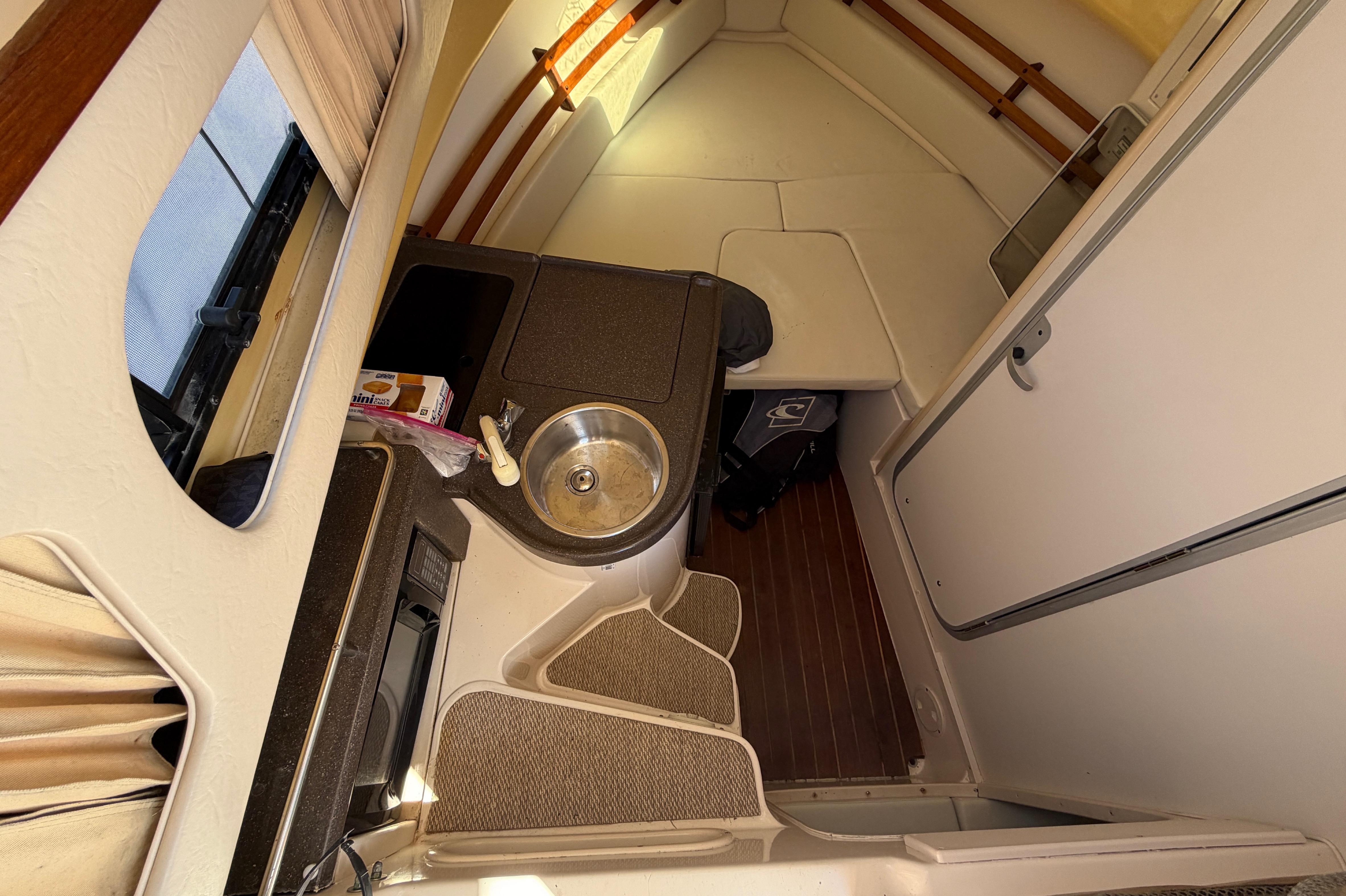 2006 Grady-White Sailfish 282 cabin interior with kitchenette and seating area.