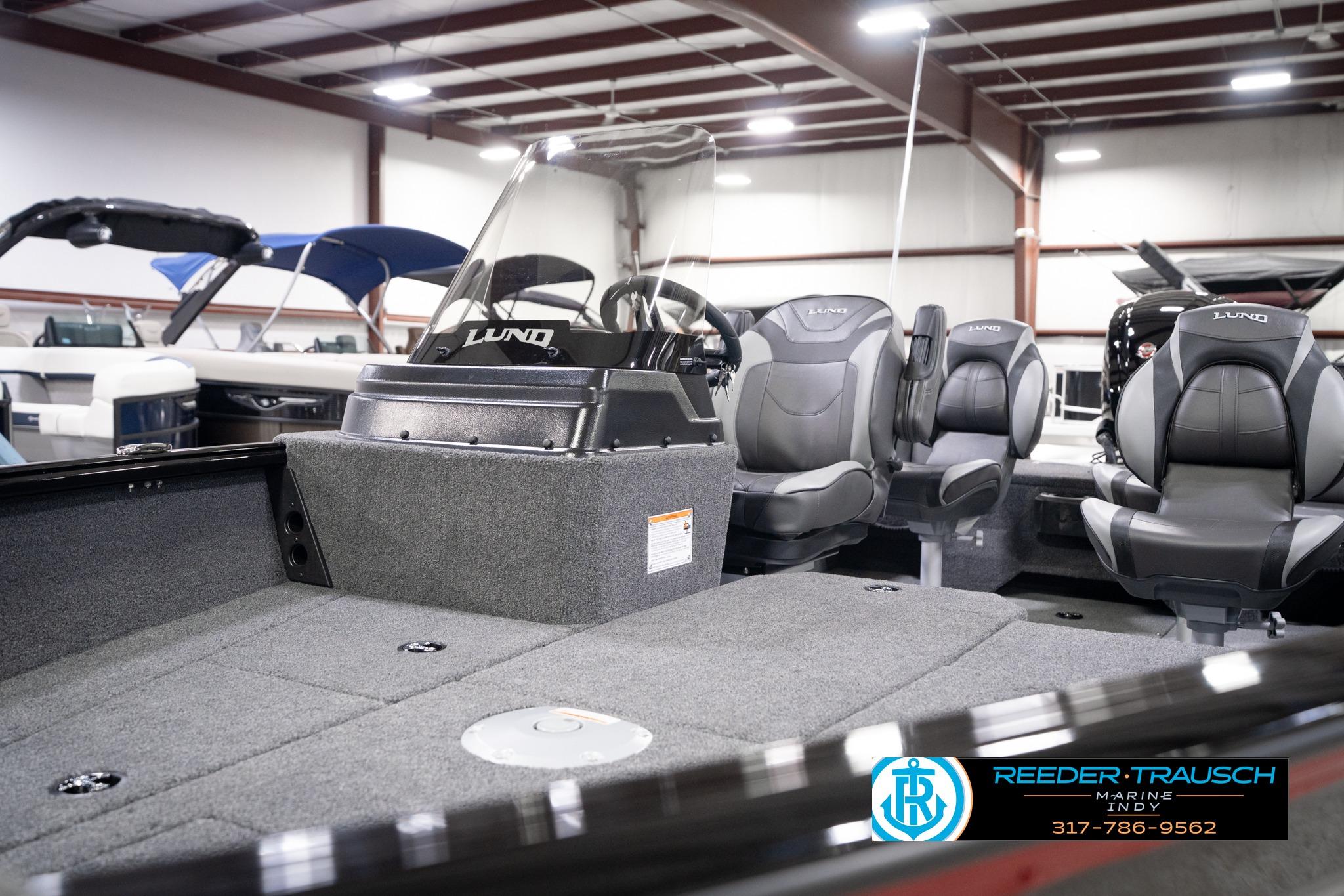 2026 Lund 1775 Impact XS SS boat interior with seating and console in showroom.