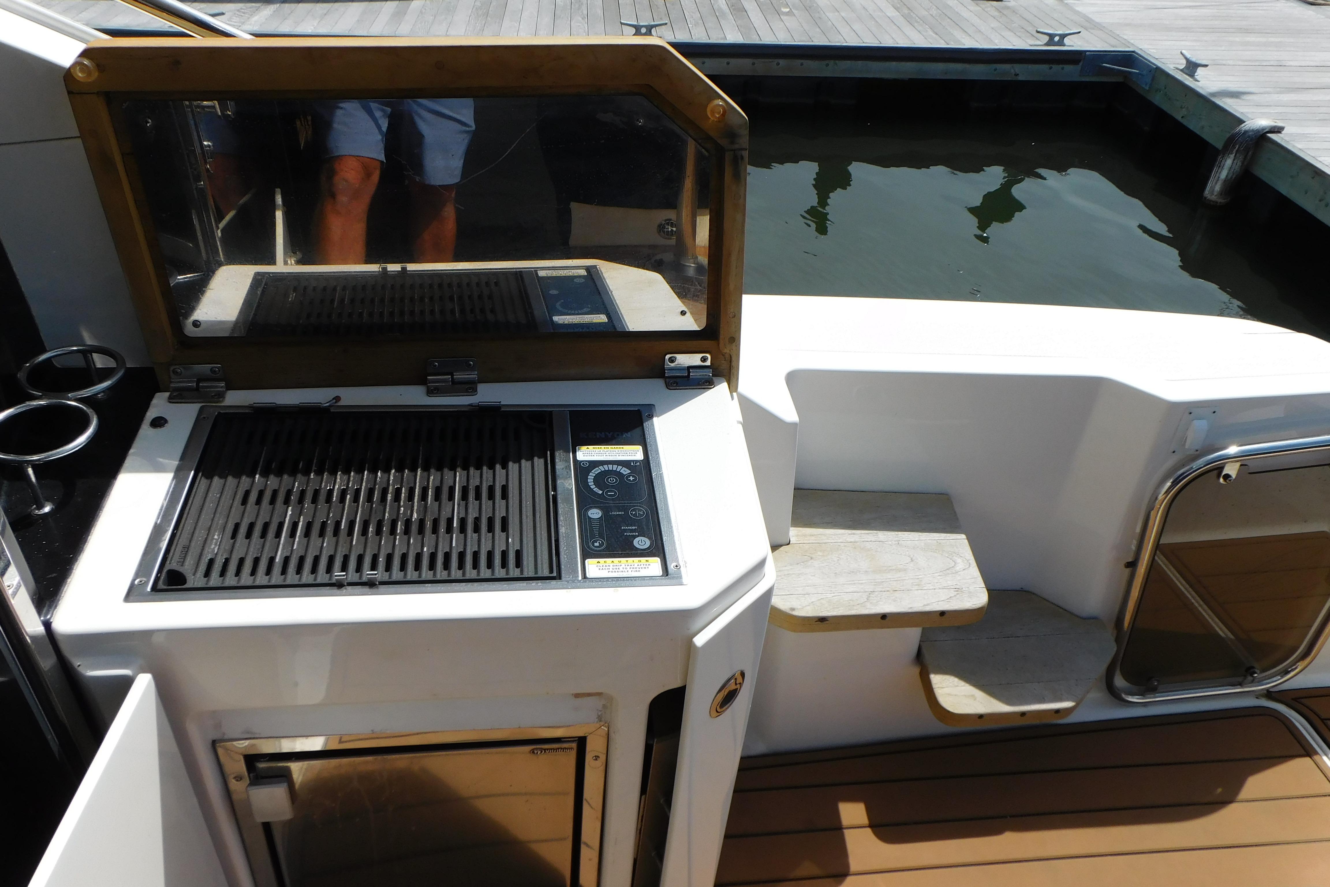 Outdoor grill on 2013 Sea Ray 510 Sundancer yacht deck near water.