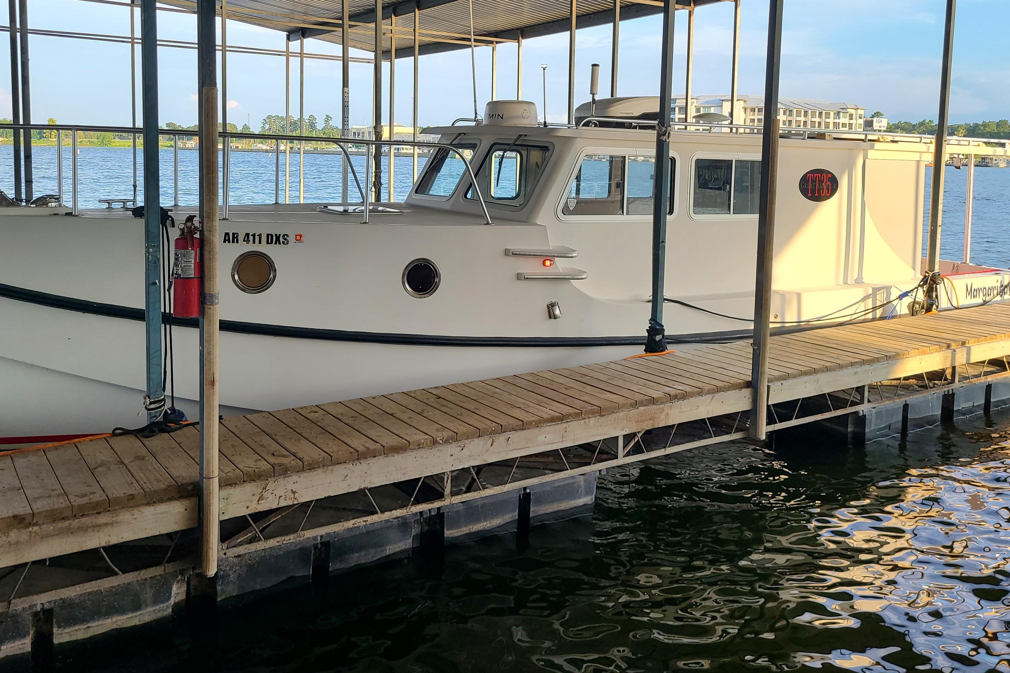 2018 Great Harbour TT35 boat docked in a marina, surrounded by calm water.