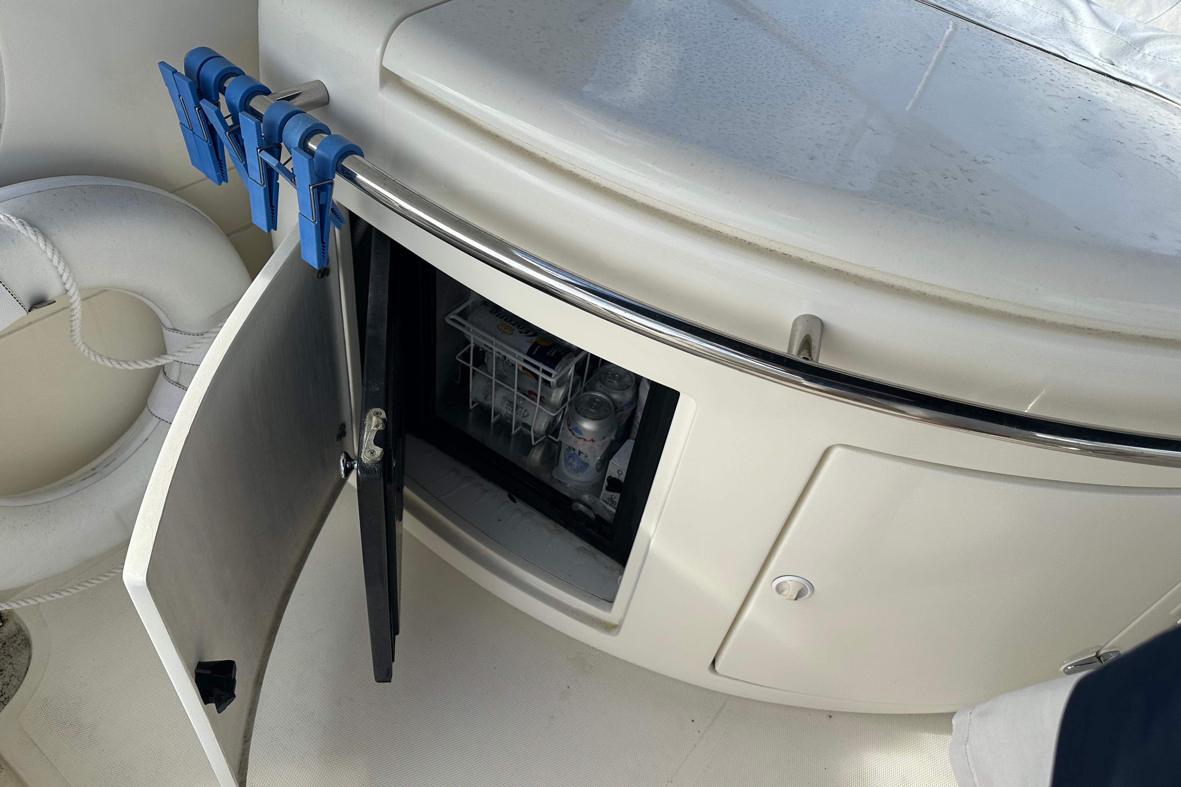 Open storage compartment on 2004 Azimut 55E yacht with visible interior items.