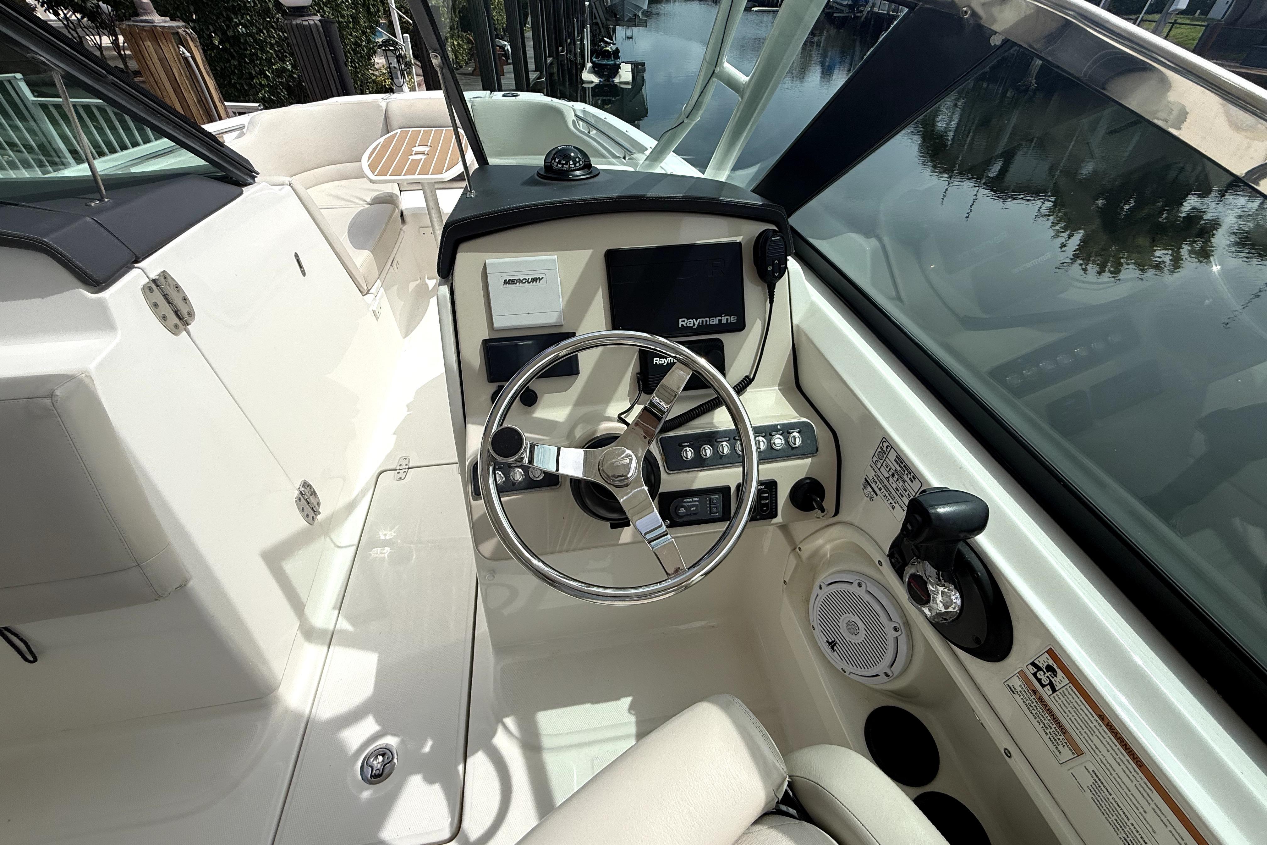 2018 Boston Whaler 230 Vantage boat cockpit with steering wheel and control panel.