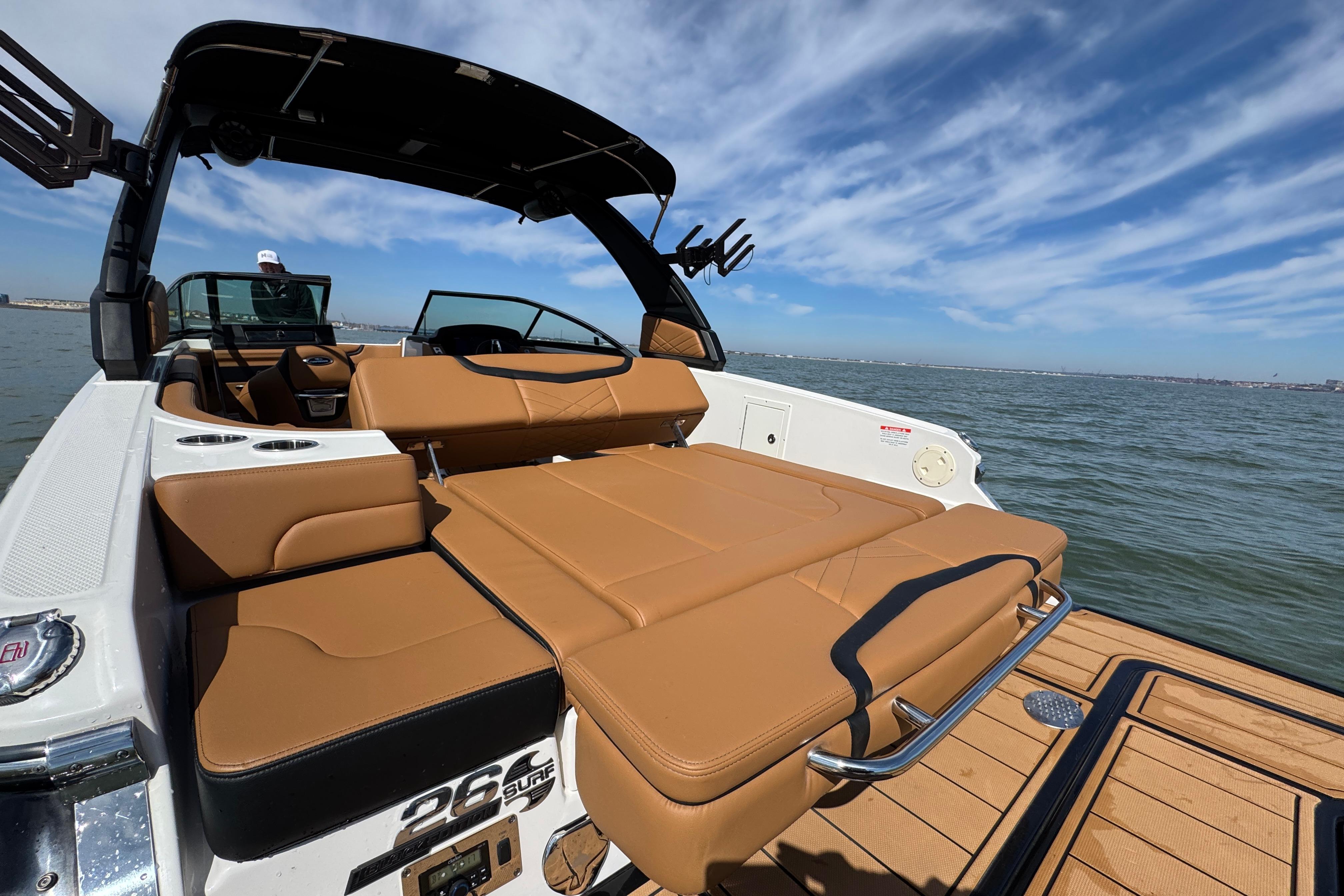 2023 Chaparral 26 Surf boat with tan seating, on a sunny day at sea.