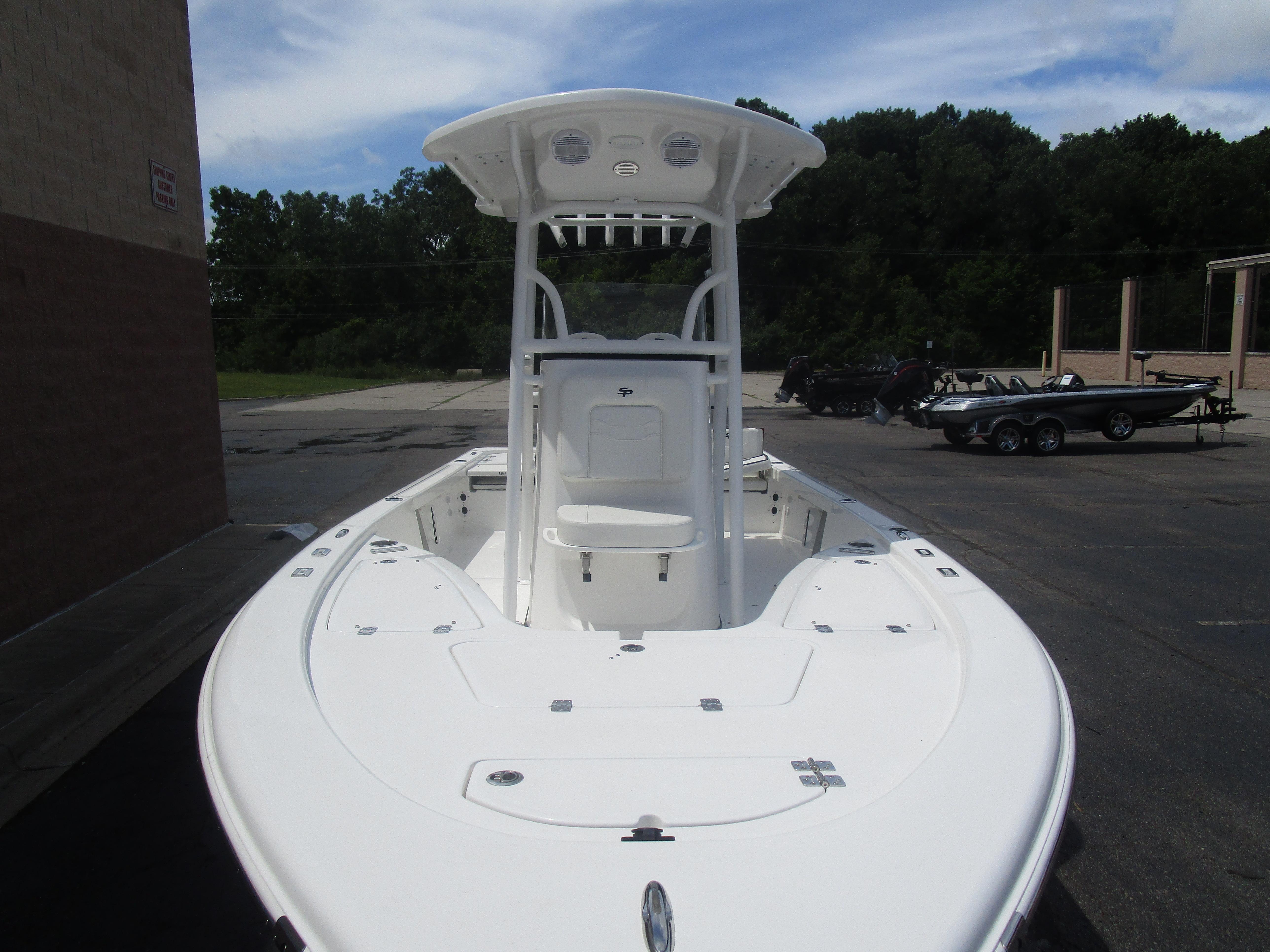 2025 Sea Pro 230 DLX BAY boat with T-top, parked outdoors on a sunny day.