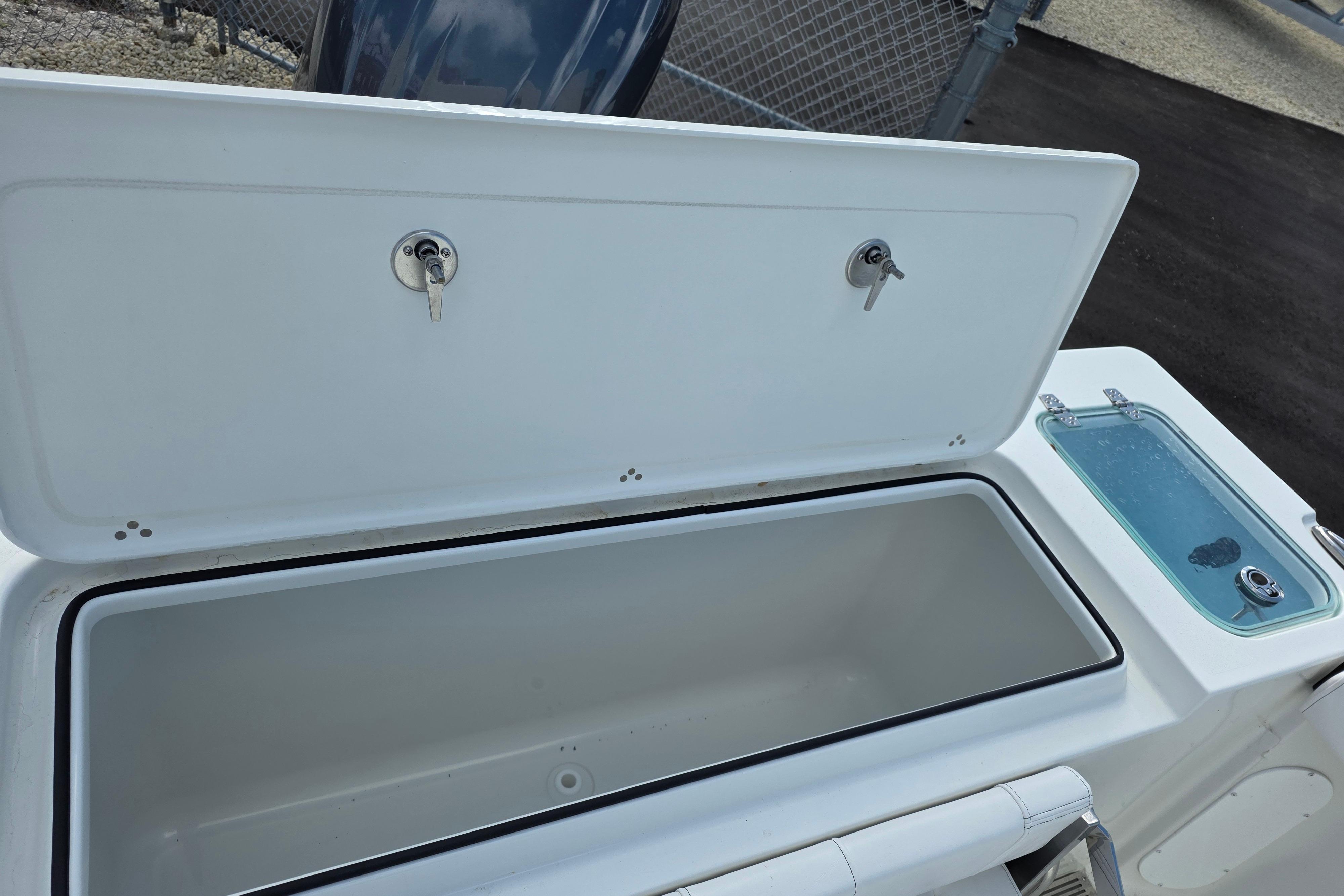 Open storage compartment on 2026 Parker 227 Explorer boat, featuring secure locks and adjacent sink.