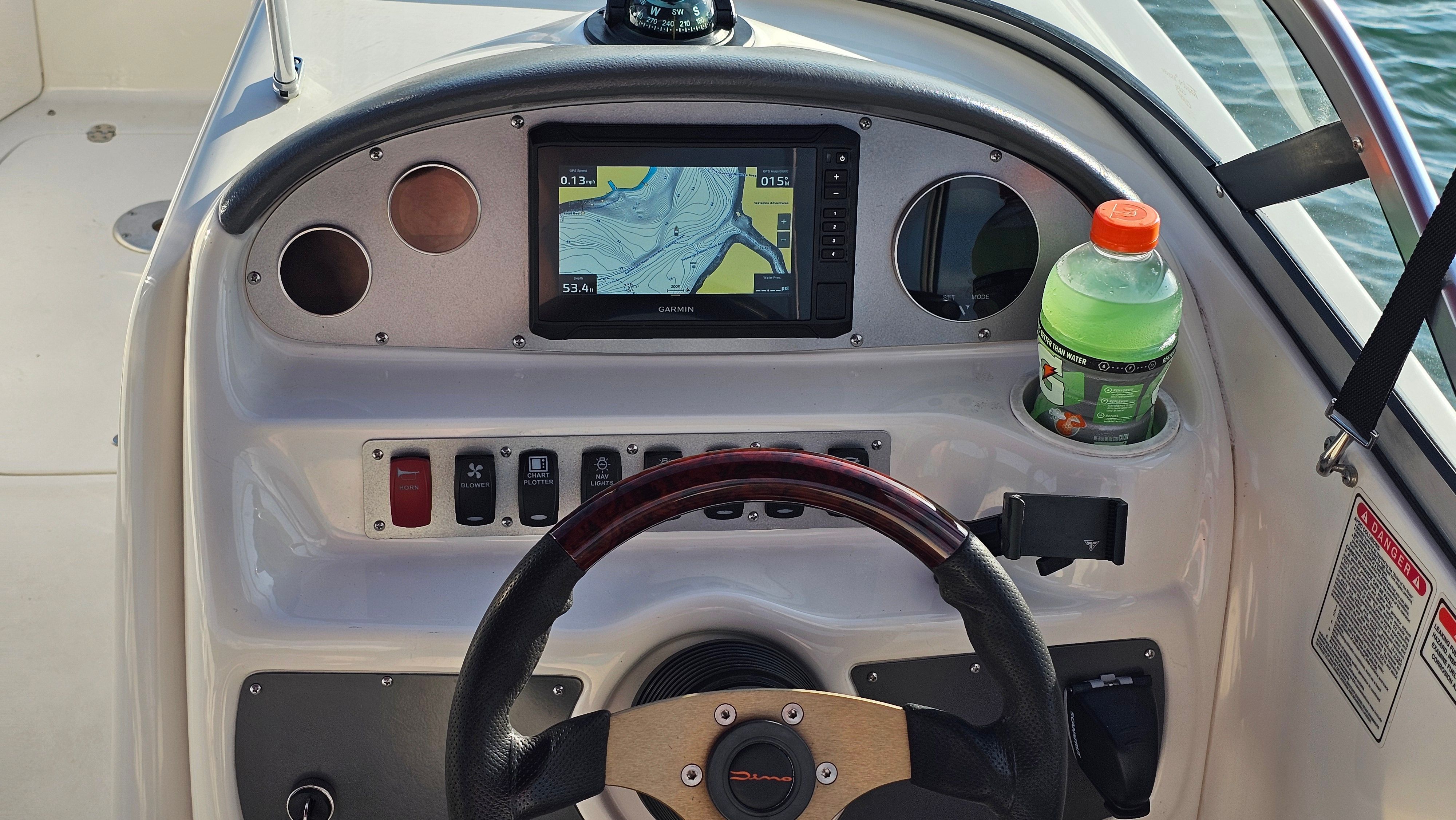 The cockpit of a 2002 Monterey 220 Explorer Sport with a navigation system and cup holder.