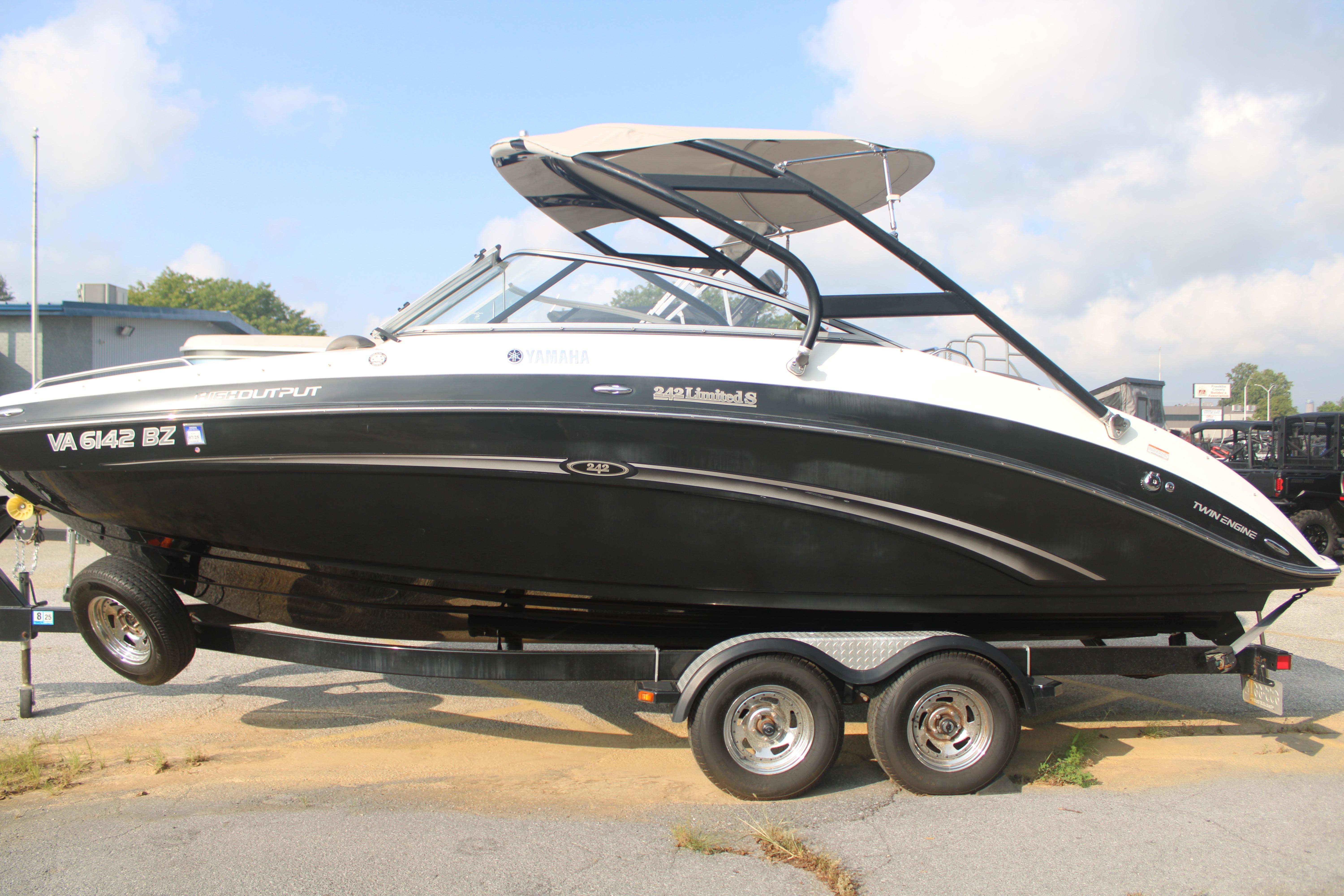 2013 Yamaha Boats 242 Limited S on trailer, black and white design, parked outdoors.