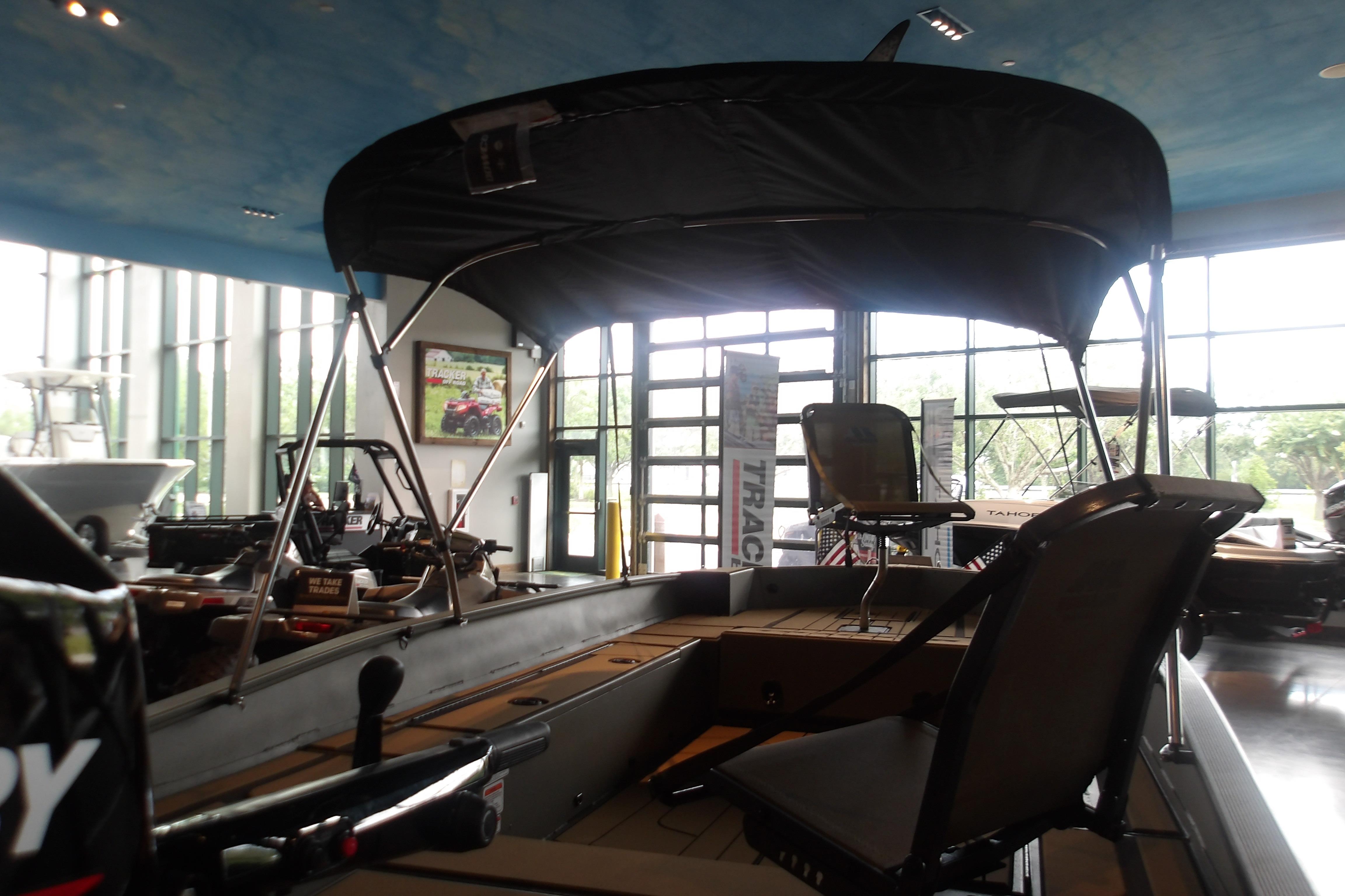 2026 Tracker Grizzly 1756 T Marsh boat displayed indoors with canopy and seating.