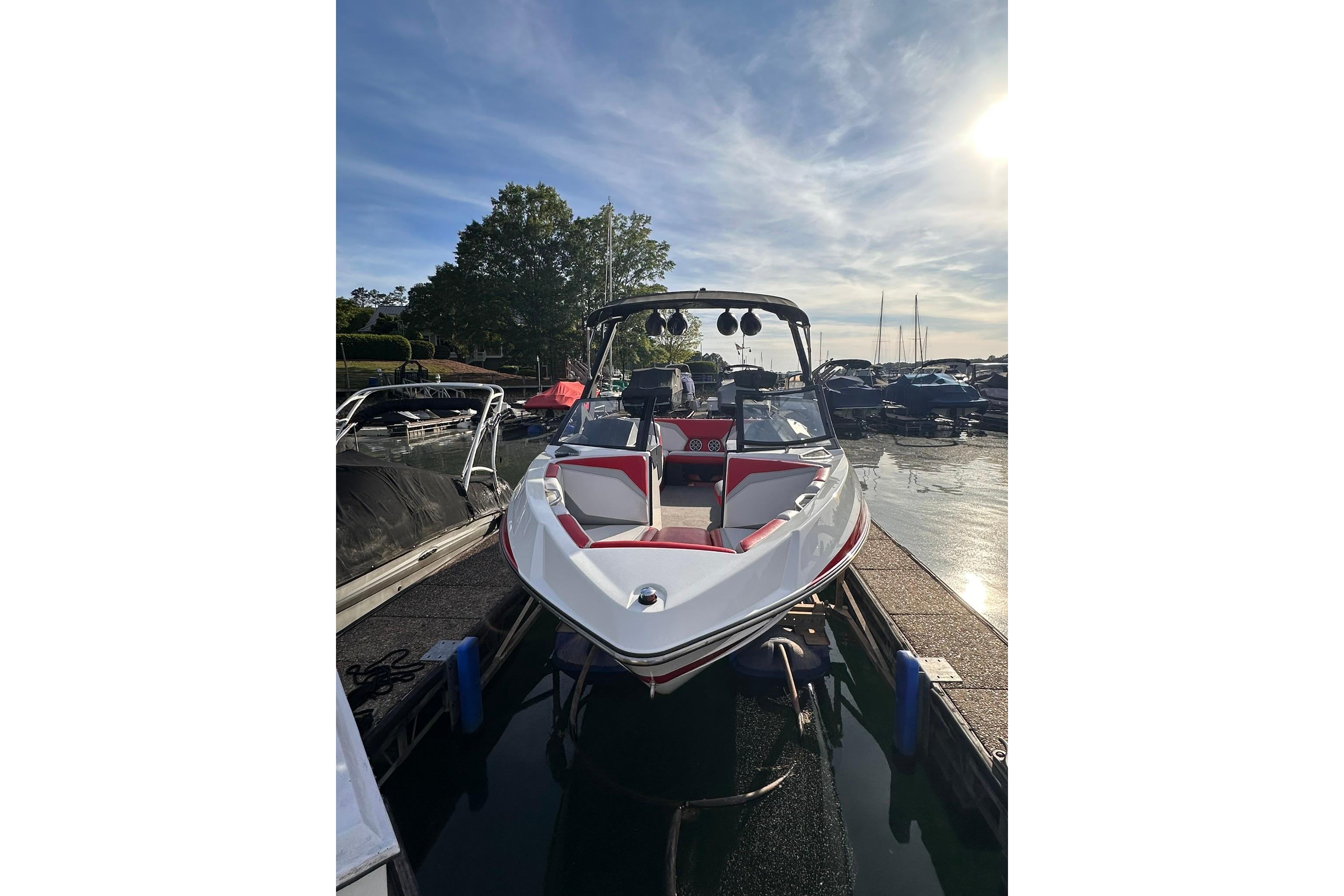2017 Axis T23 boat docked at marina under clear sky.