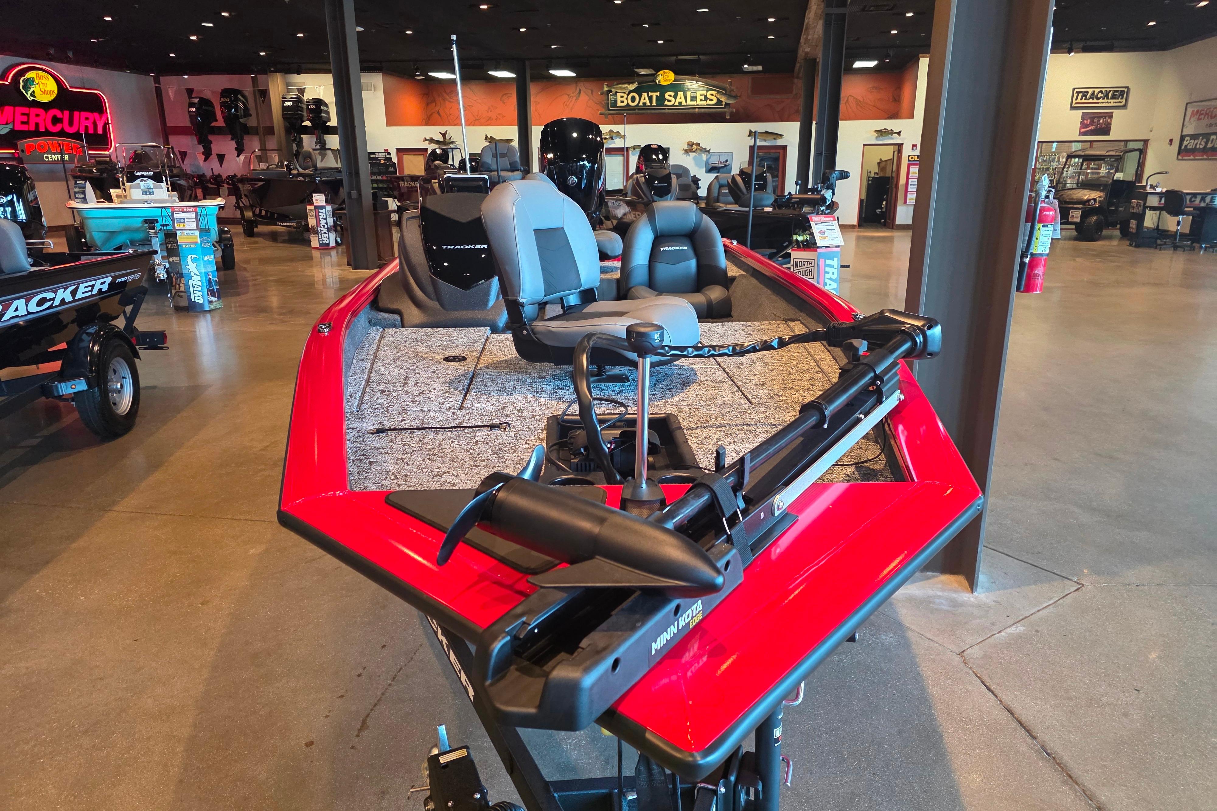 2026 Tracker Pro Team 175 boat displayed in a showroom with red exterior and seating.