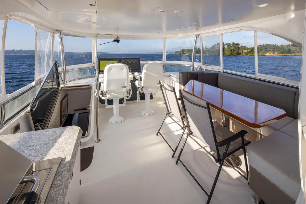 Luxurious 2017 Ocean Alexander 70e yacht interior with seating, helm, and ocean view.